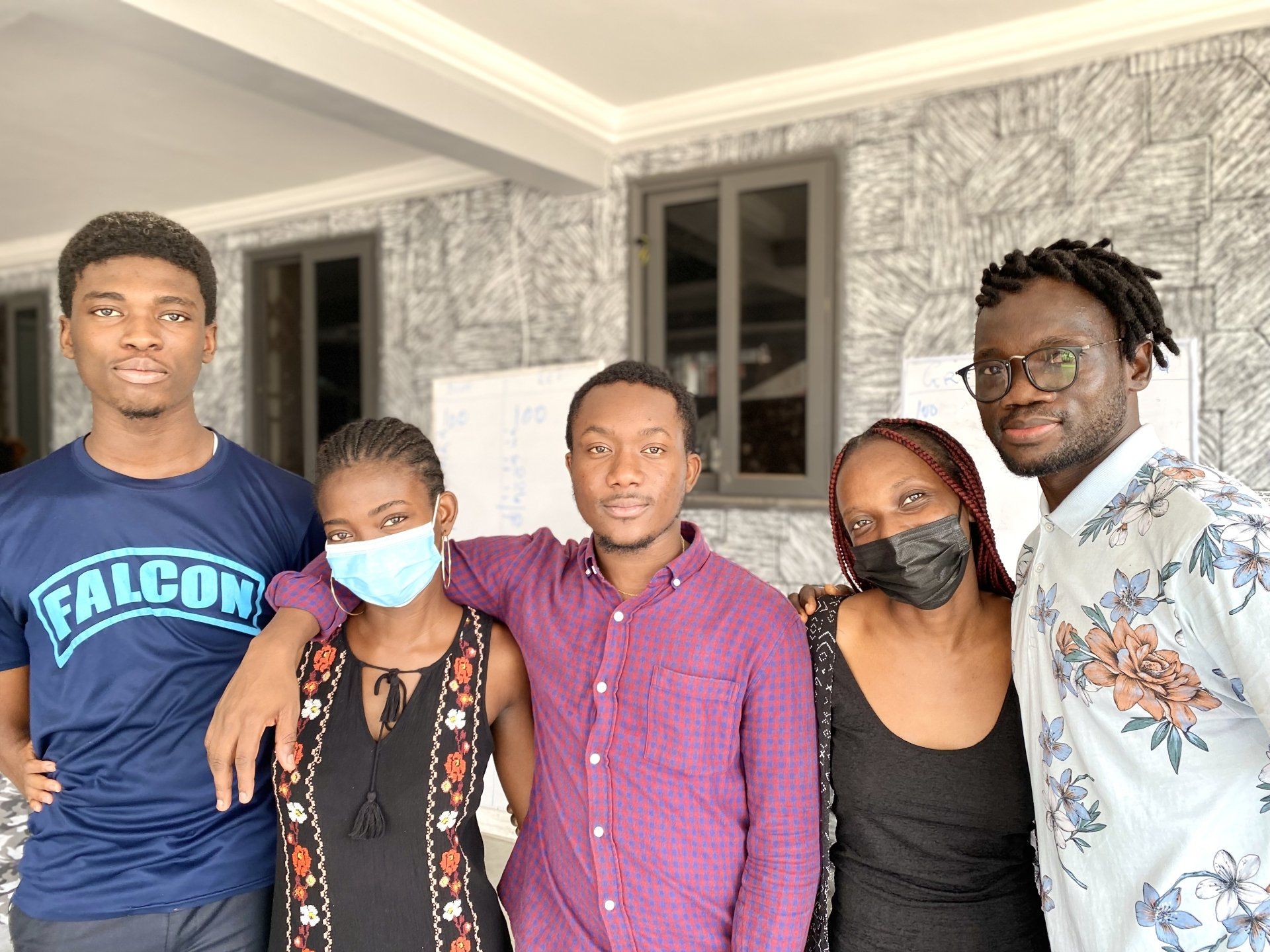 Un groupe de personnes portant des masques posent pour une photo.