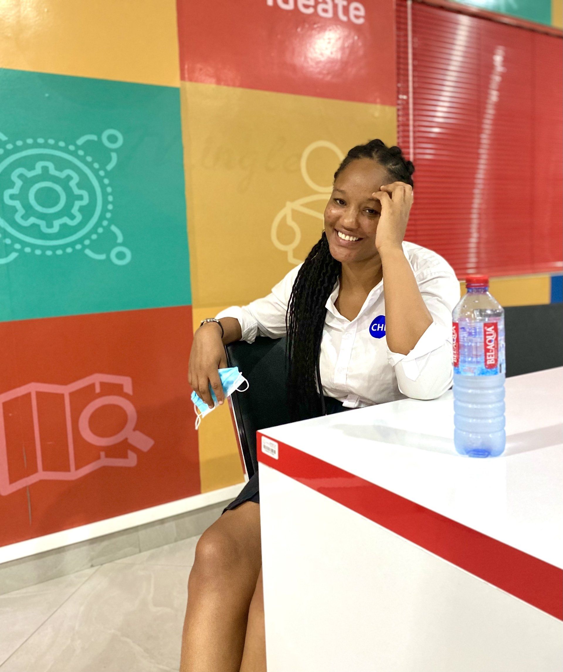 Une femme est assise à un bureau avec une bouteille d'eau aquafina à côté d'elle