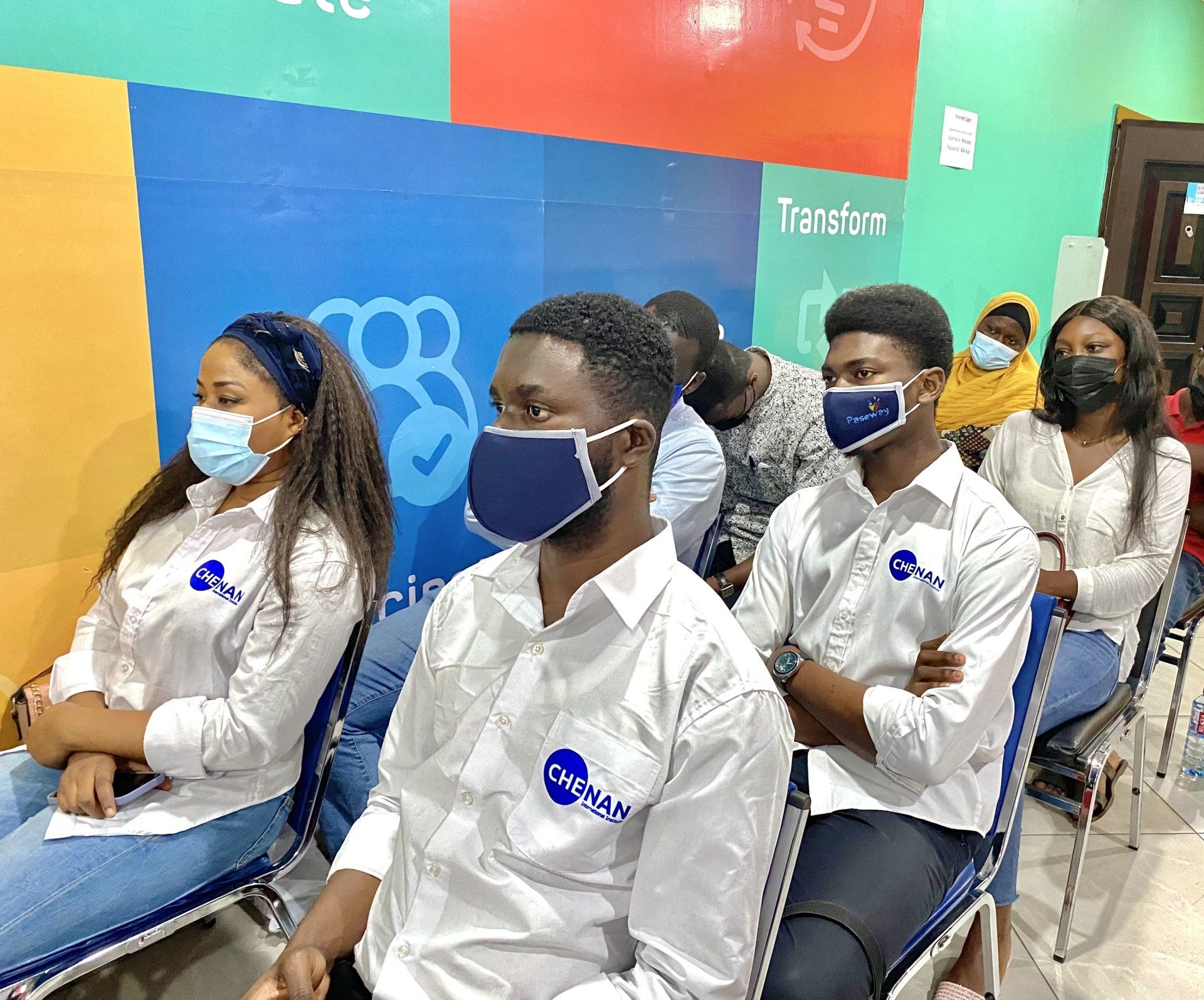 Un groupe de personnes portant des masques sont assis sur des chaises.