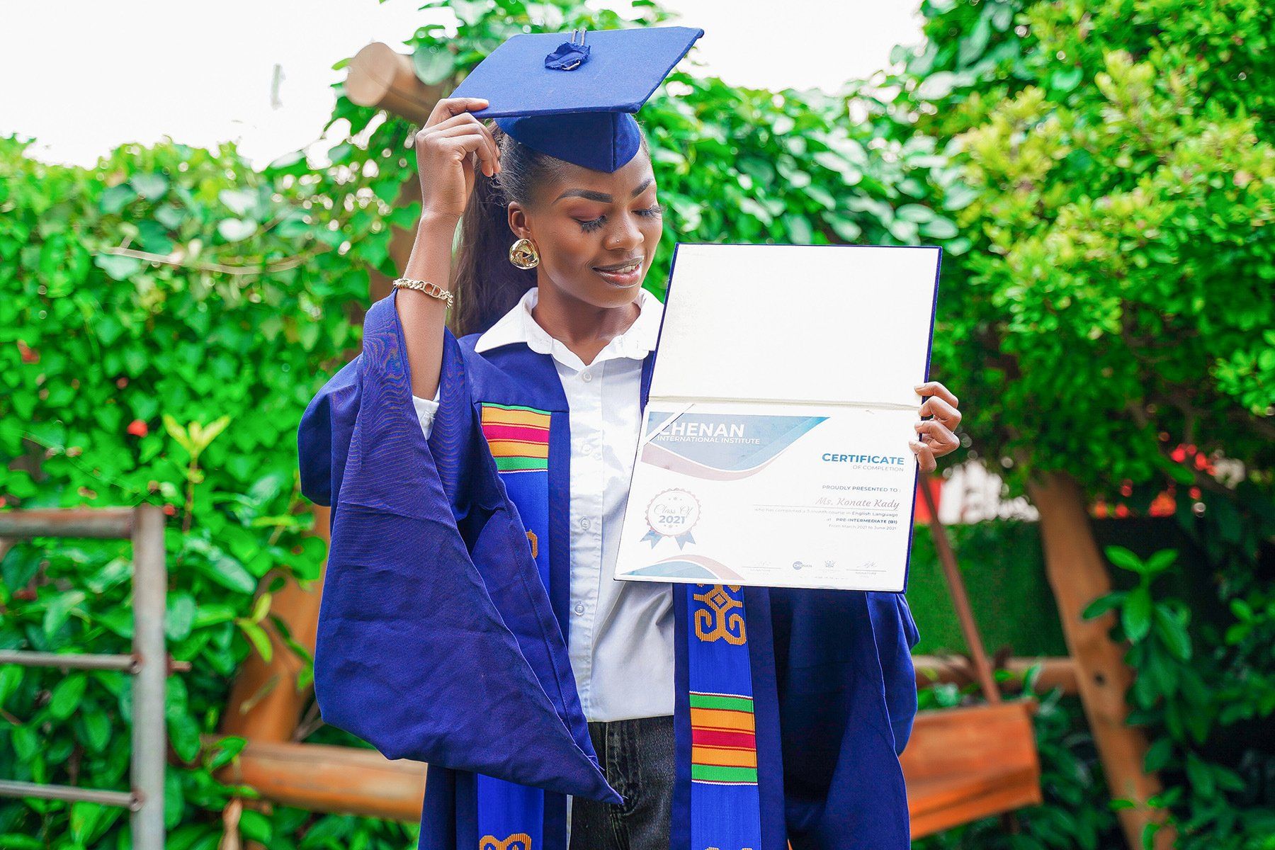 Une  apprenante en fin de sejour portant sa toge de graduation