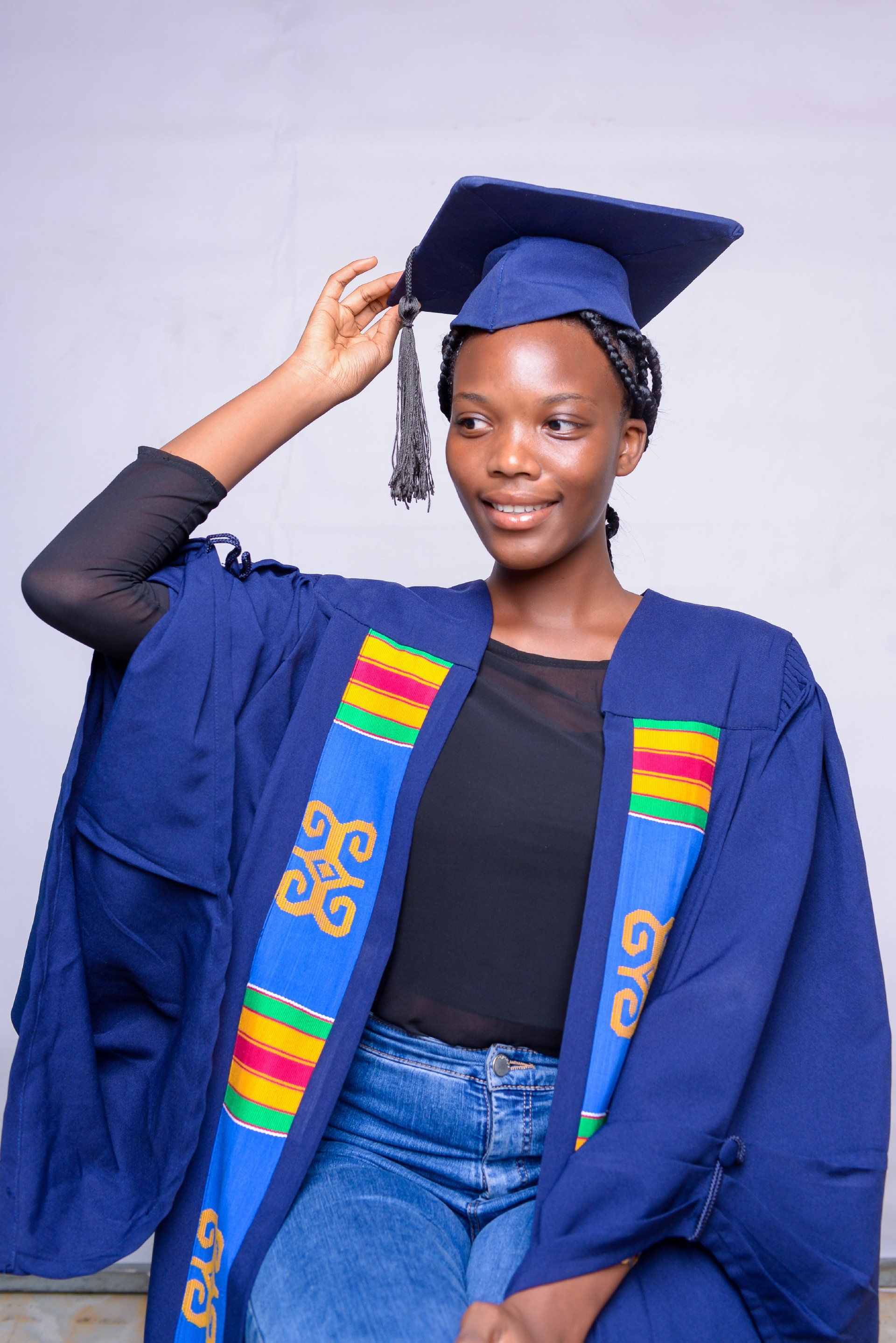 Une femme porte une casquette et une robe de graduation.