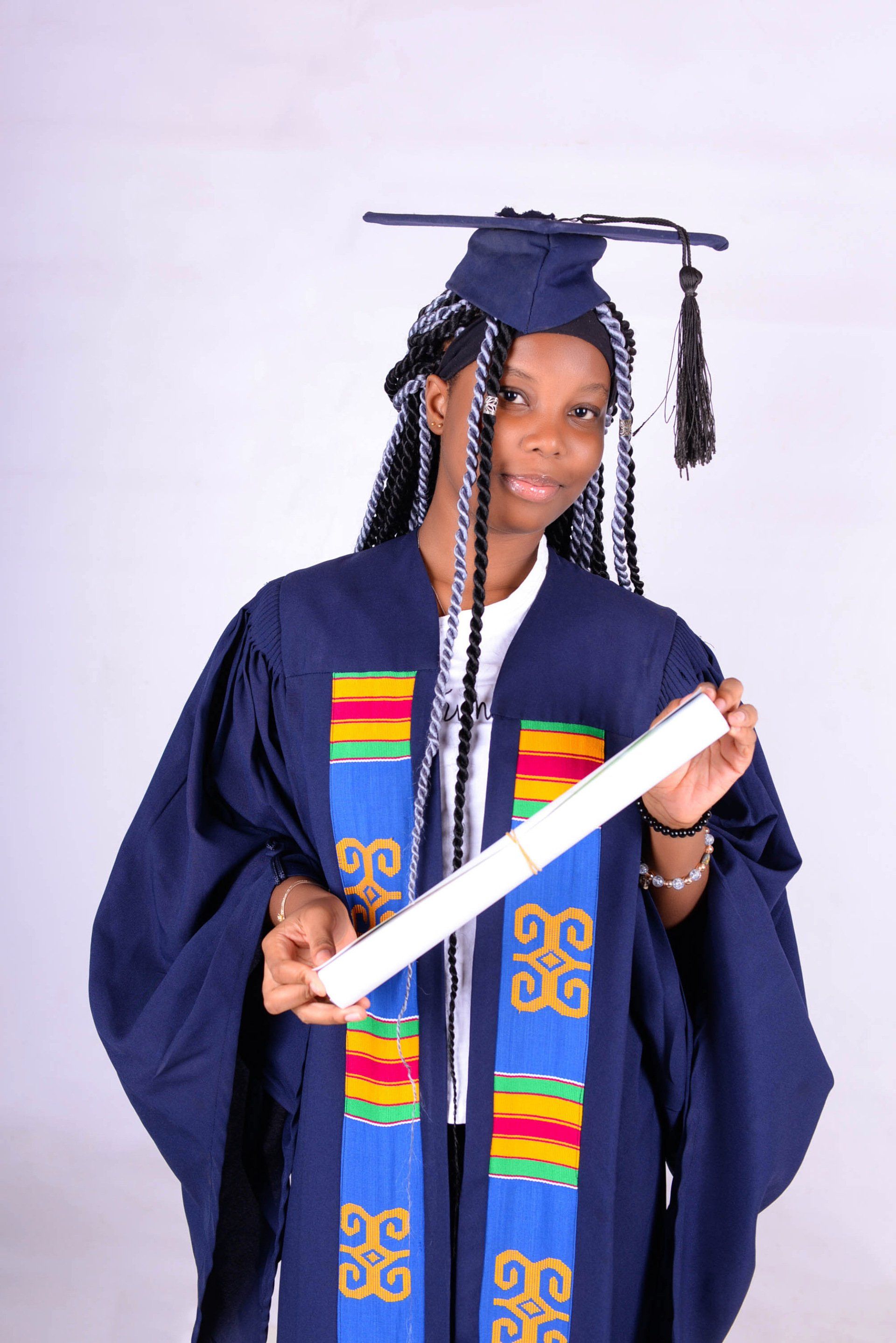 Une femme portant une casquette et une robe de graduation est titulaire d'un diplôme
