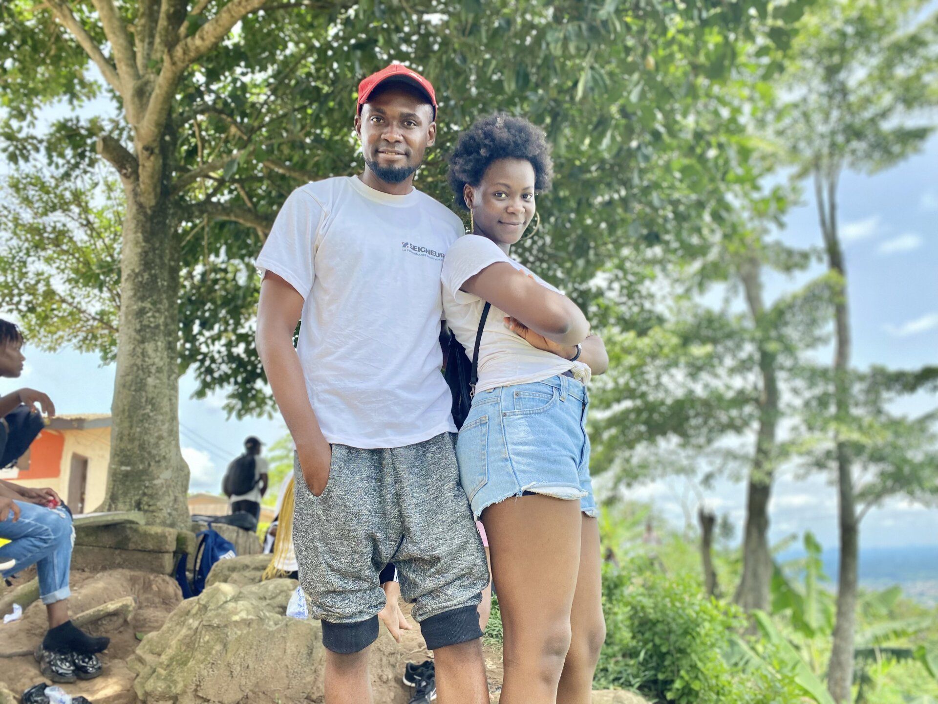 Un homme et une femme se tiennent côte à côte devant un arbre.