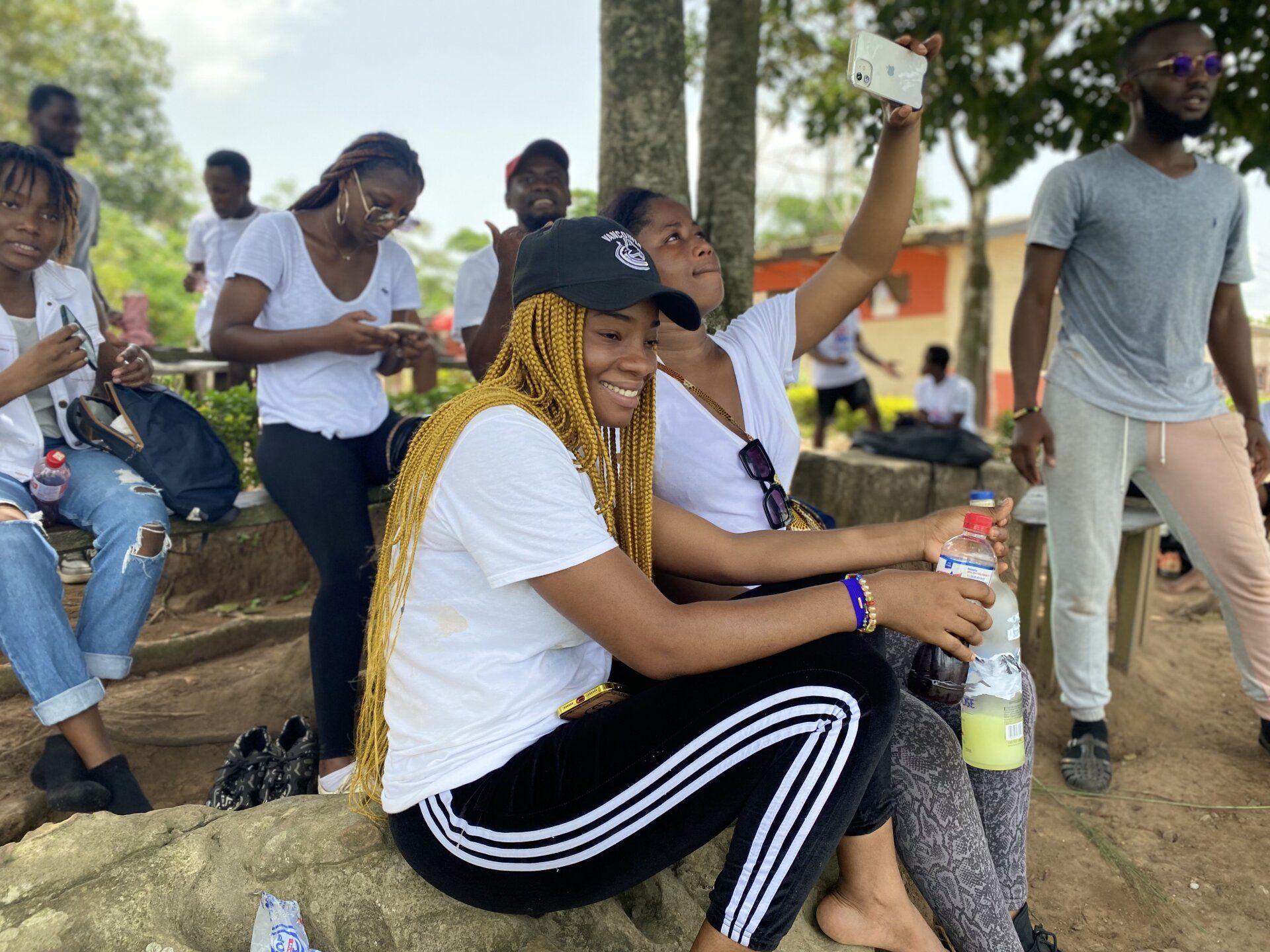 Un groupe de personnes est assise sur un rocher dans un parc.