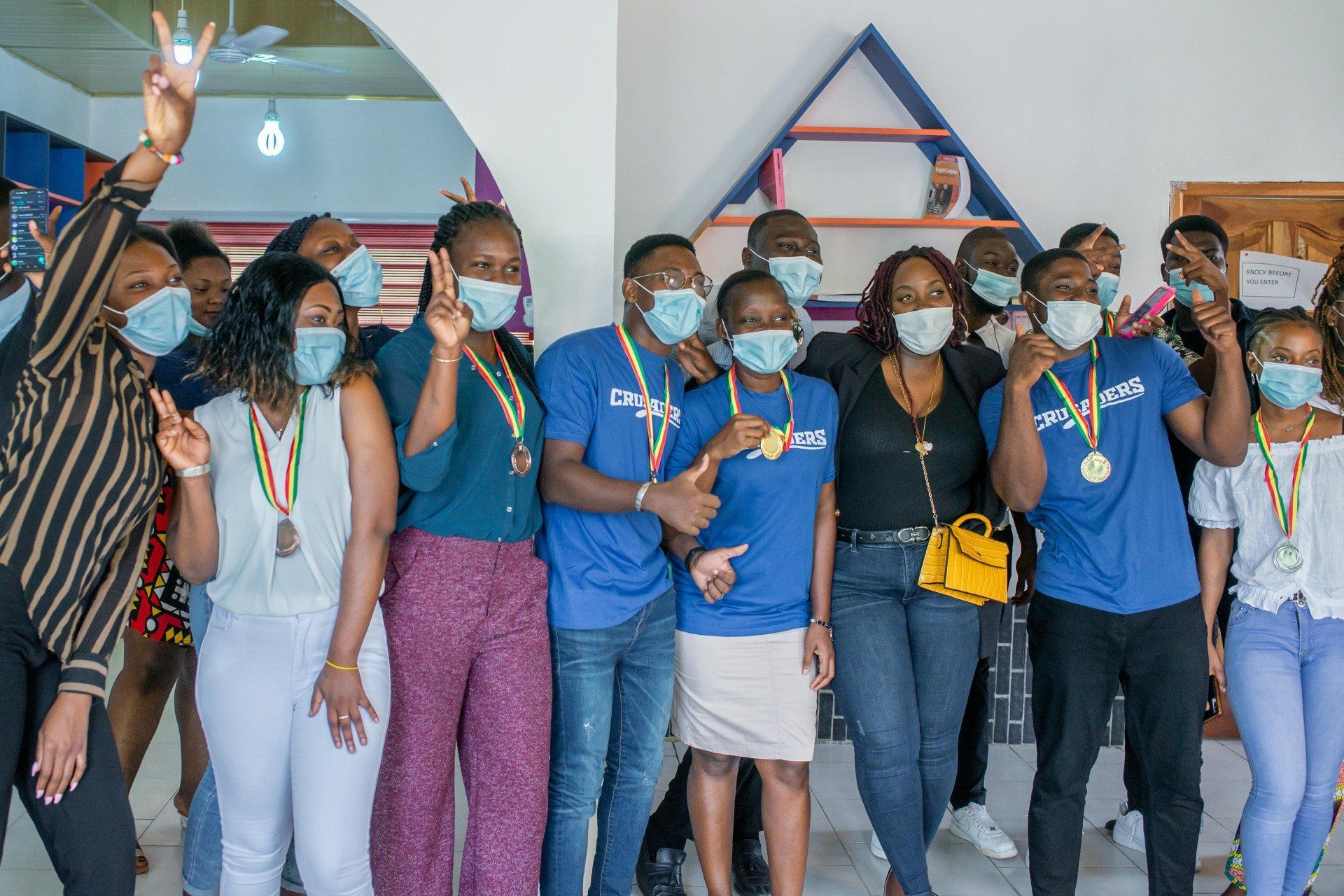 Un groupe de personnes portant des masques et des médailles posent pour une photo.