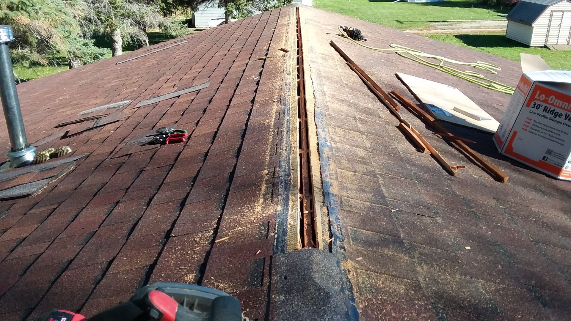Peak of Roof Cut Open with Atlas Burnt Sienna Colored Shingles near Tower City, ND