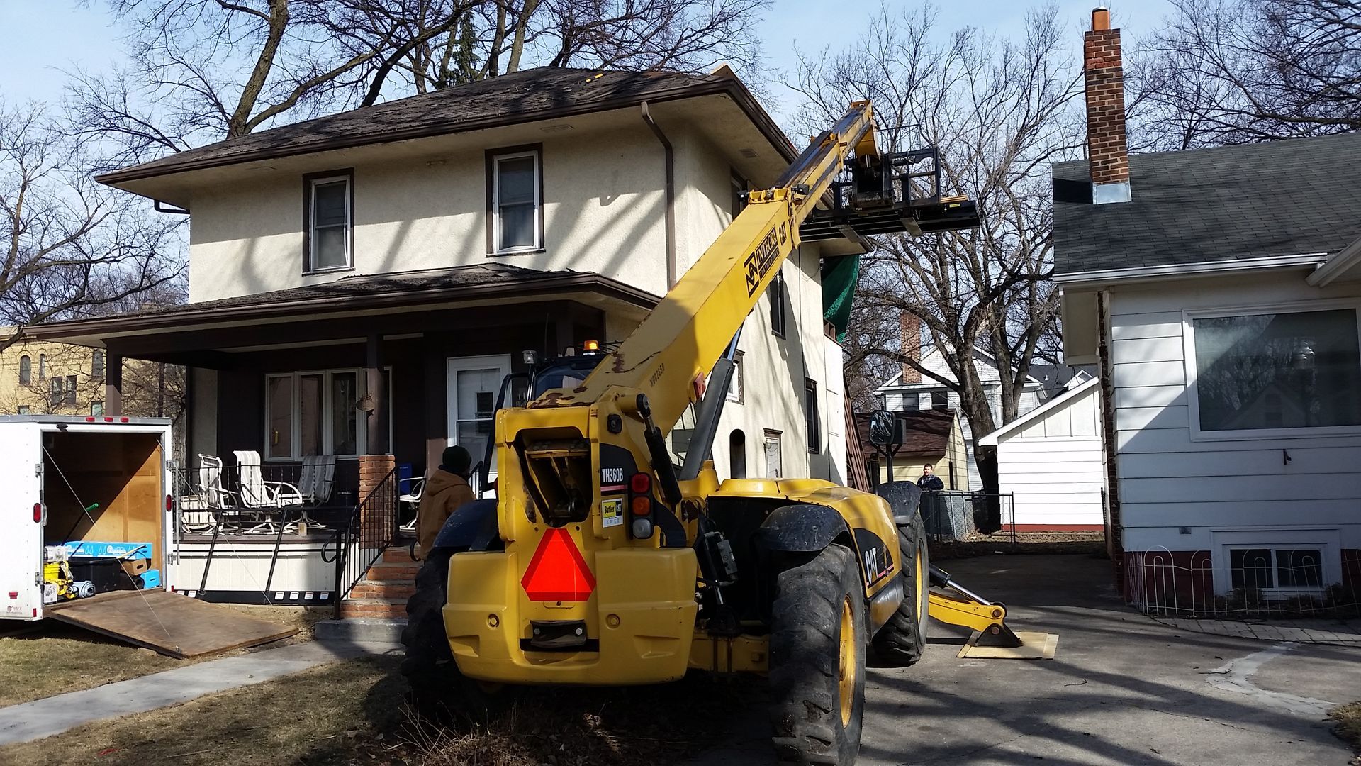 Telehandler Lifting Roofing Material onto a Home near Fargo-Moorhead