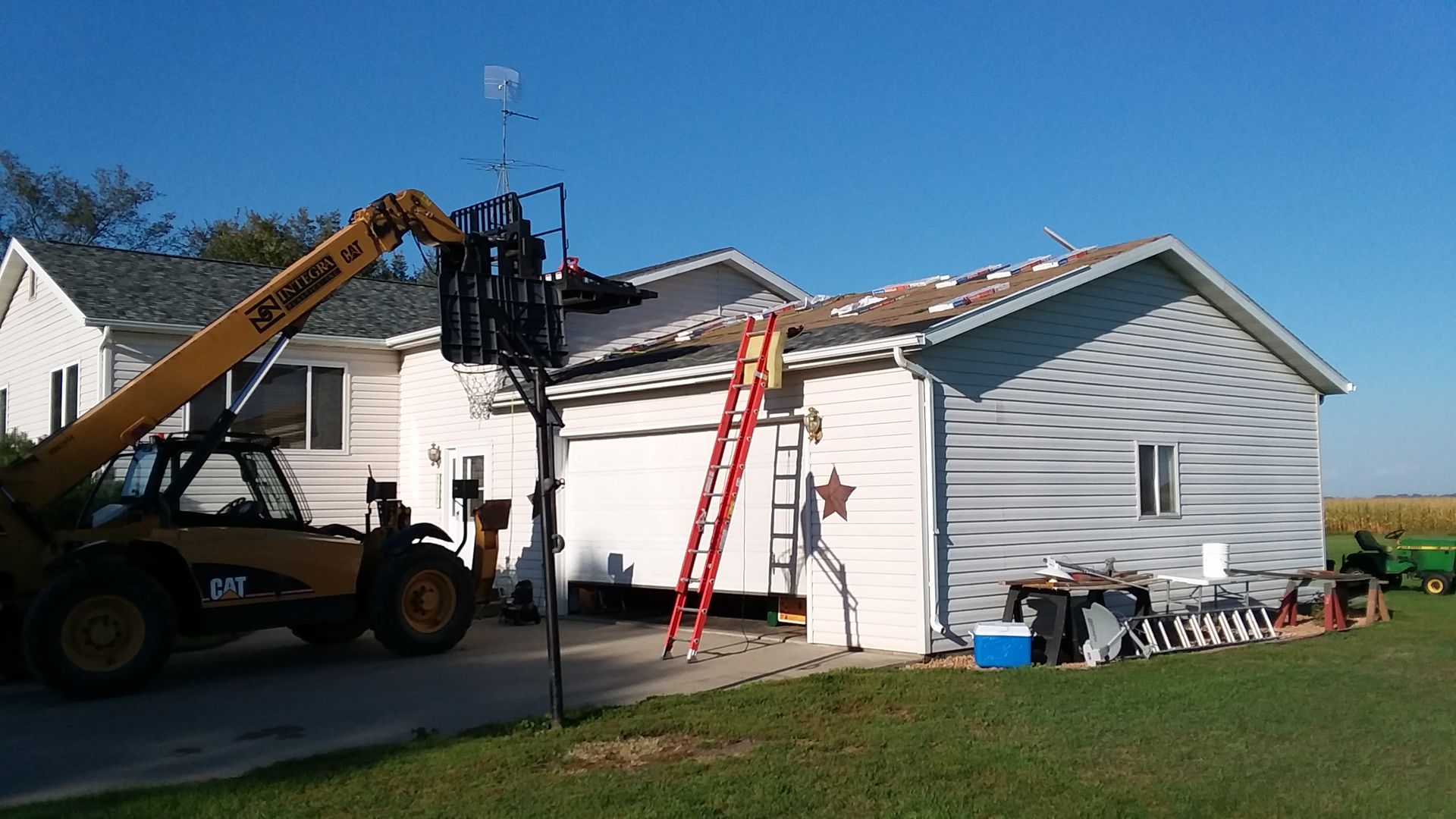 Bundles of Granite Class IV Shingles on a Roof Using a Forklift in the lakes country area of west central Minnesota