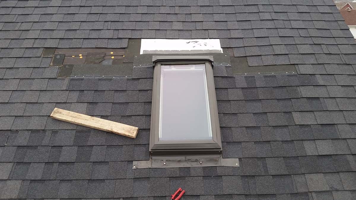 Shingles Being Weaved into Metal Flashing to Repair a Skylight near Mapleton-ND