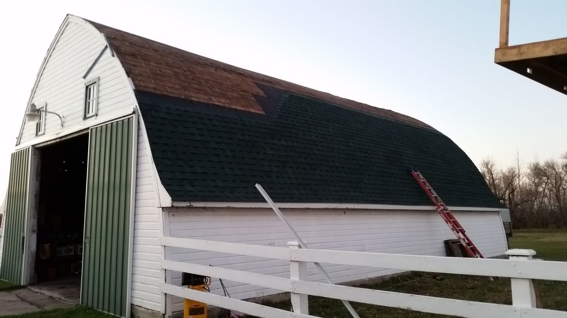 White Barn with Roofing Felt and Green Asphalt Shingles Installed near Buffalo-ND
