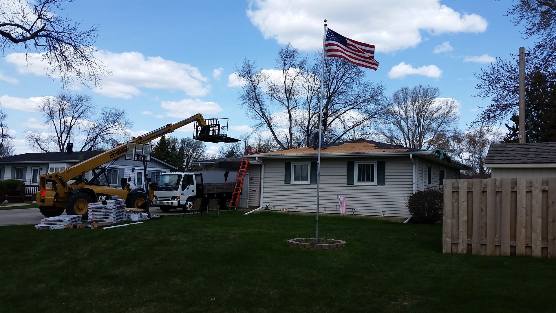 Dump Truck with Roof Debris and Forklift Lifting Roofing Material to Eave in Northwood-ND