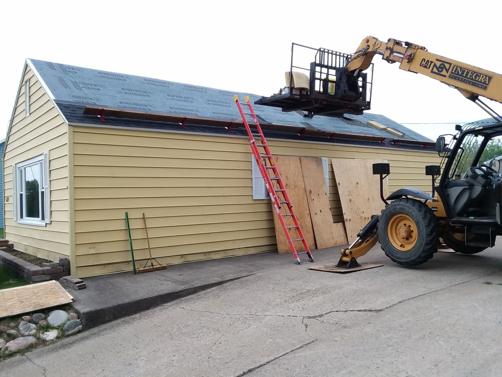 Forklift Next to Gray Synthetic Felt and Atlas Shingles on a Roof in Crookston, MN