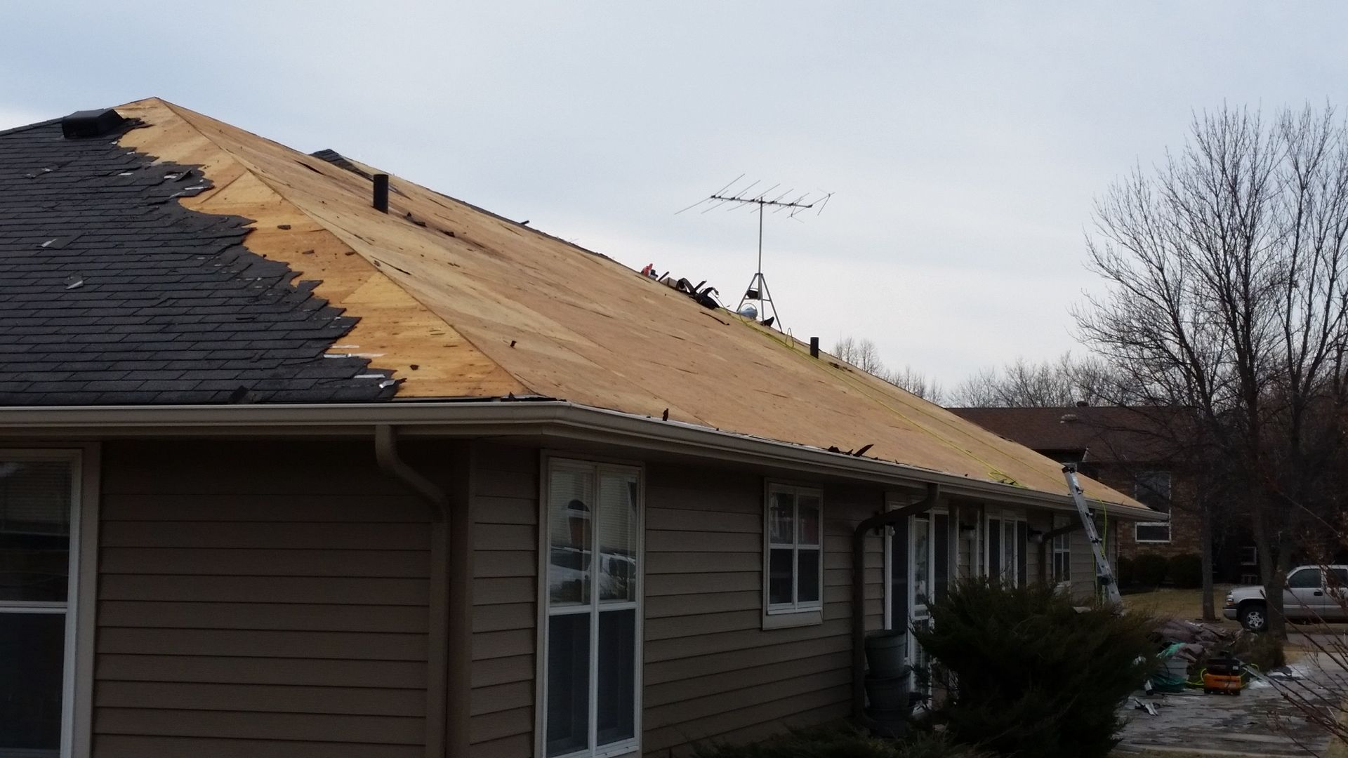 House with Half of the Roof Shingles Removed with Exposed Roof Deck near Thompson ND