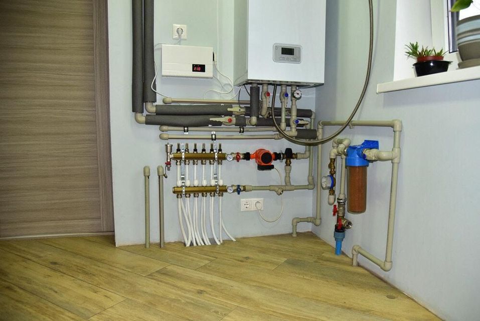 Plumbing System With Boiler, Pipes, Filter, And Control Panel On Light Blue Wall — BJG Plumbing in Coolamon, NSW