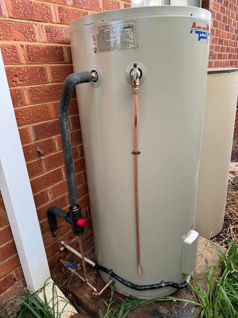 Gray Utility Box Against Blue Wall — BJG Plumbing in Ganmain, NSW