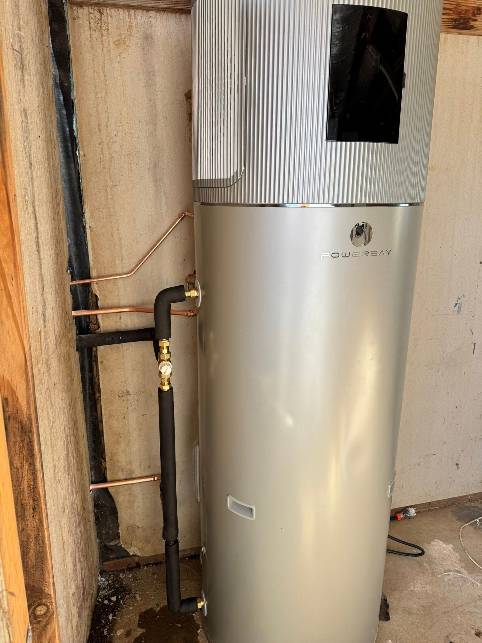 Water heater with copper pipes and black insulation in a corner — BJG Plumbing in Coolamon, NSW