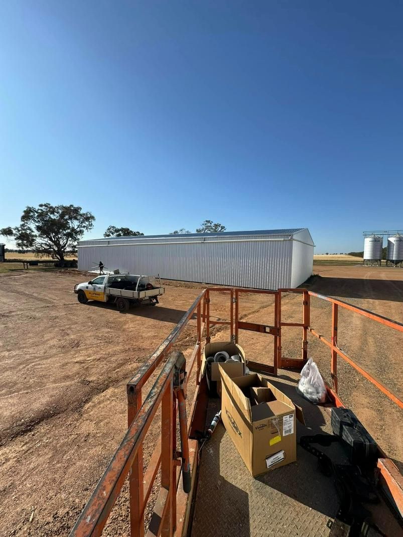 White Tarp Covering Large Building With Truck — BJG Plumbing in Ganmain, NSW