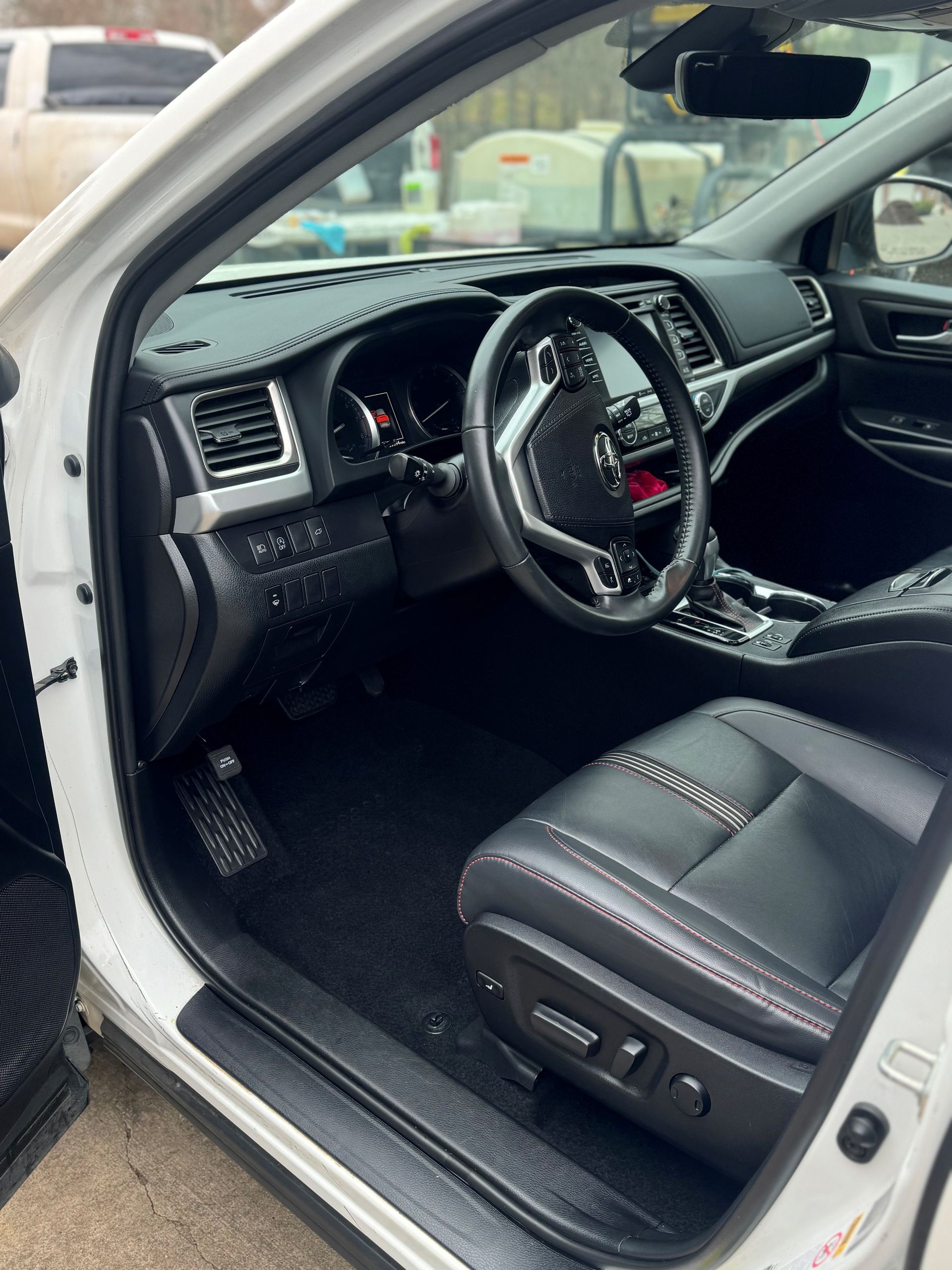 A person wearing black gloves is cleaning the dashboard of a car.