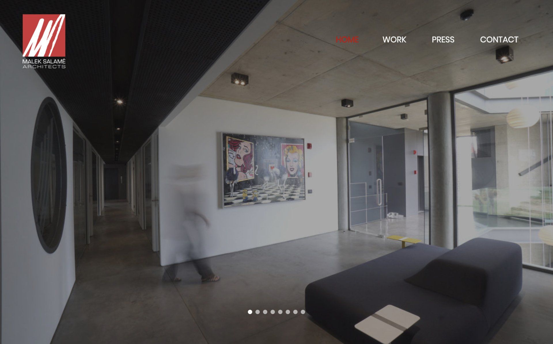 A hallway with a couch and a painting on the wall