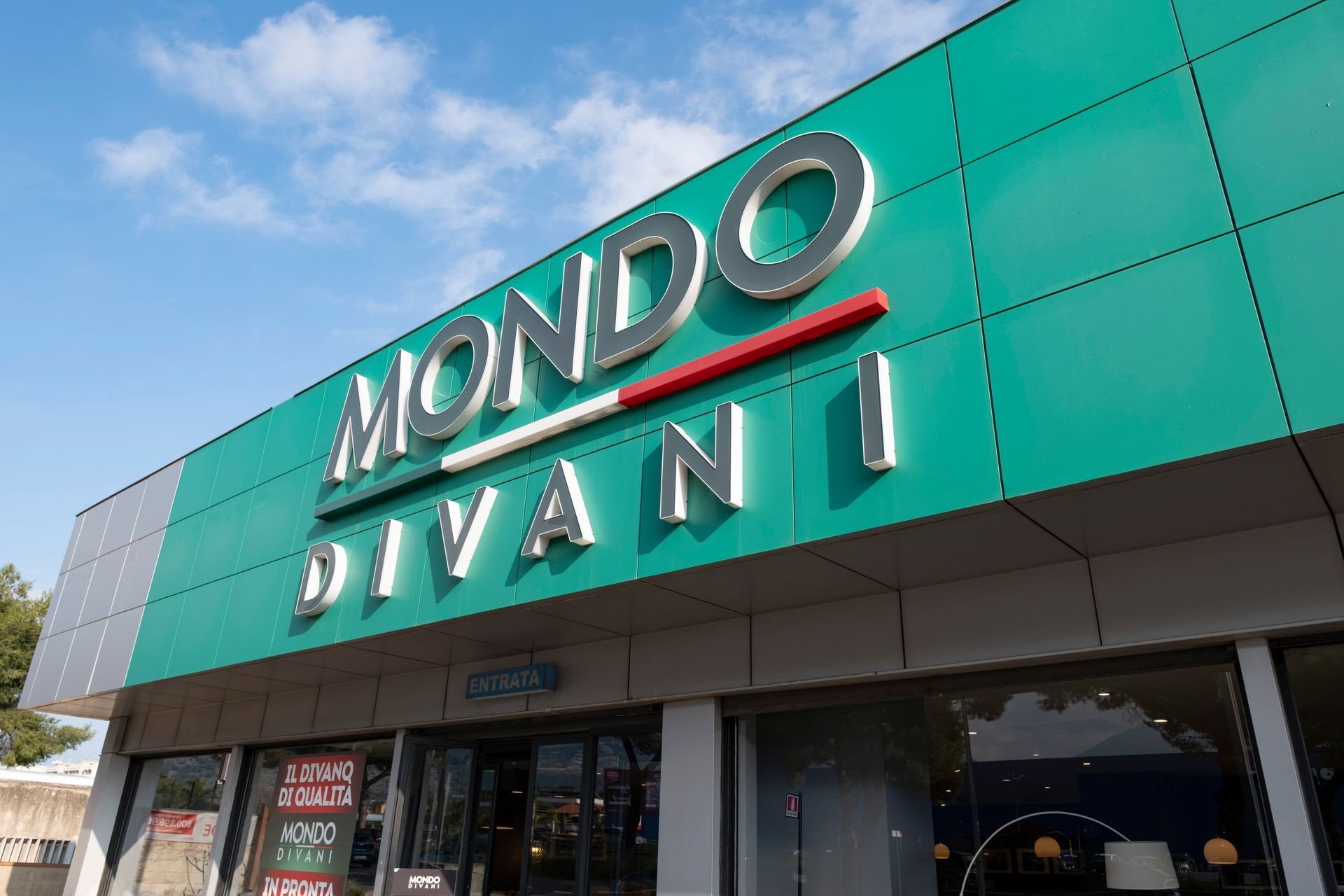 Chaise longue moderna grigio scuro con cuscino decorativo.