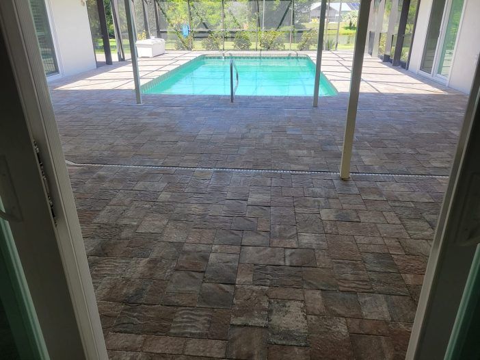 A patio with a swimming pool in the background.