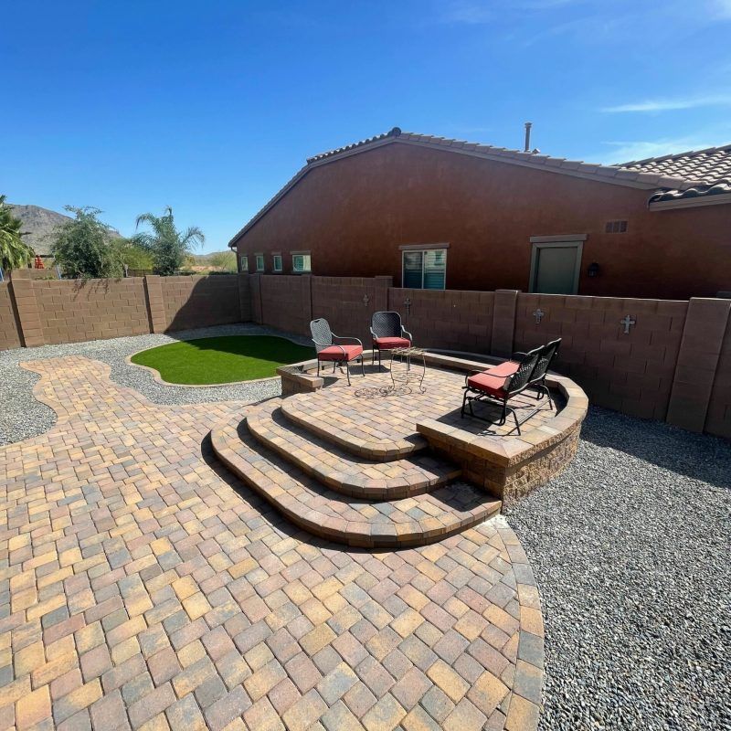 A brick driveway leading to a garage door of a house.