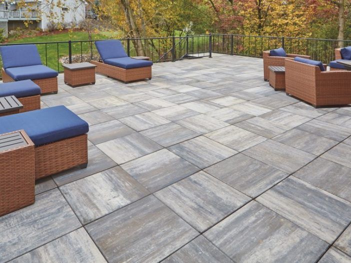 A patio with wicker furniture and blue cushions