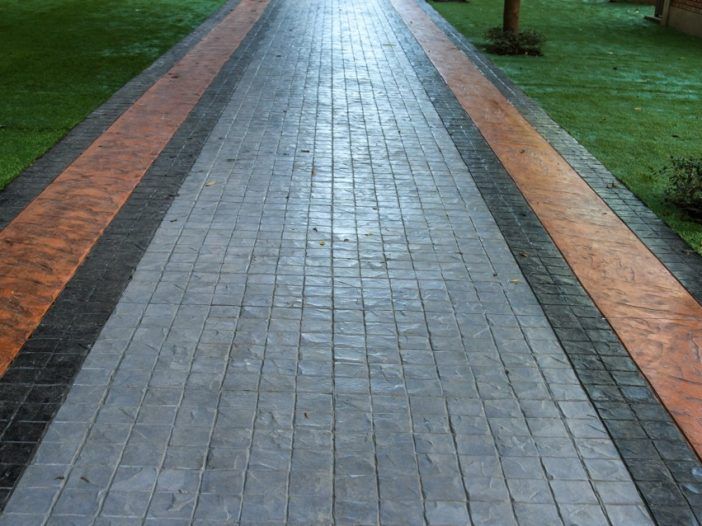 A brick walkway with a tree in the background