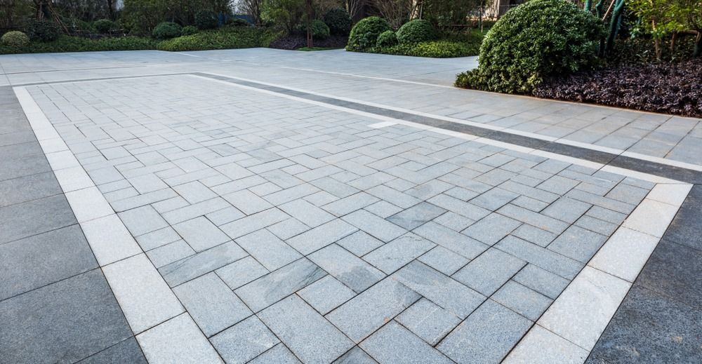 A brick driveway with a white border in a park.