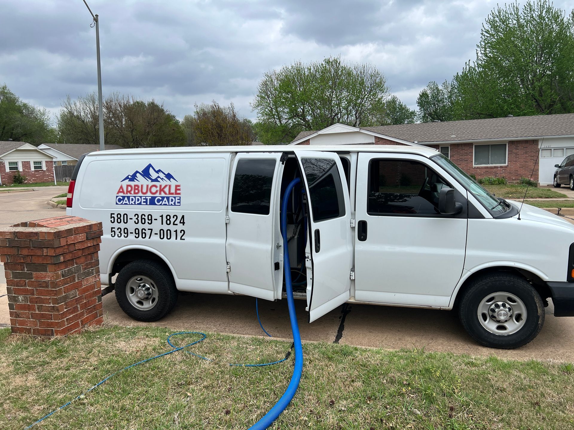 A vacuum cleaner attachment removing dust from a beige carpet, creating a clean path in the textured surface.