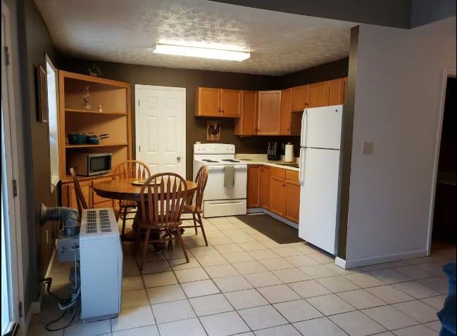 A kitchen with a table and chairs and a refrigerator