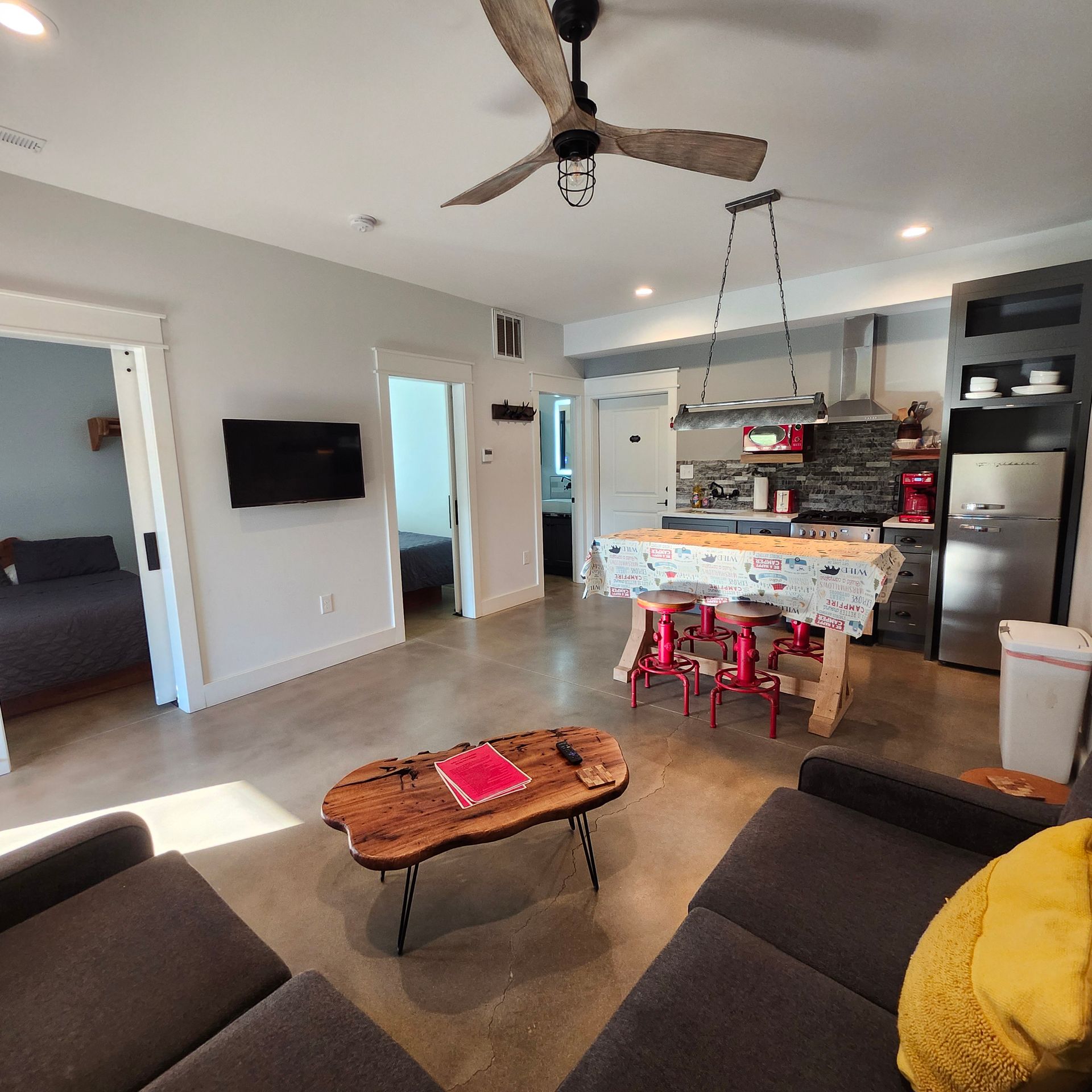 A living room with a table and chairs and a flat screen tv