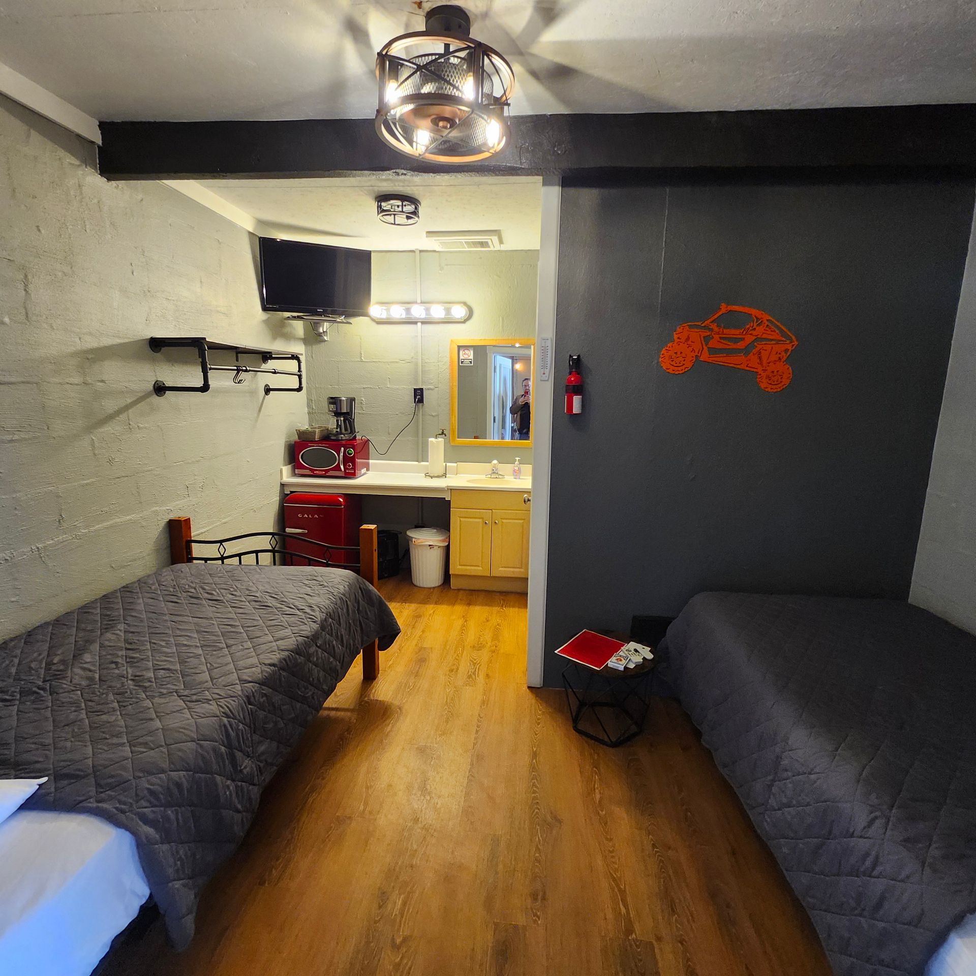 A hotel room with two beds and a sink