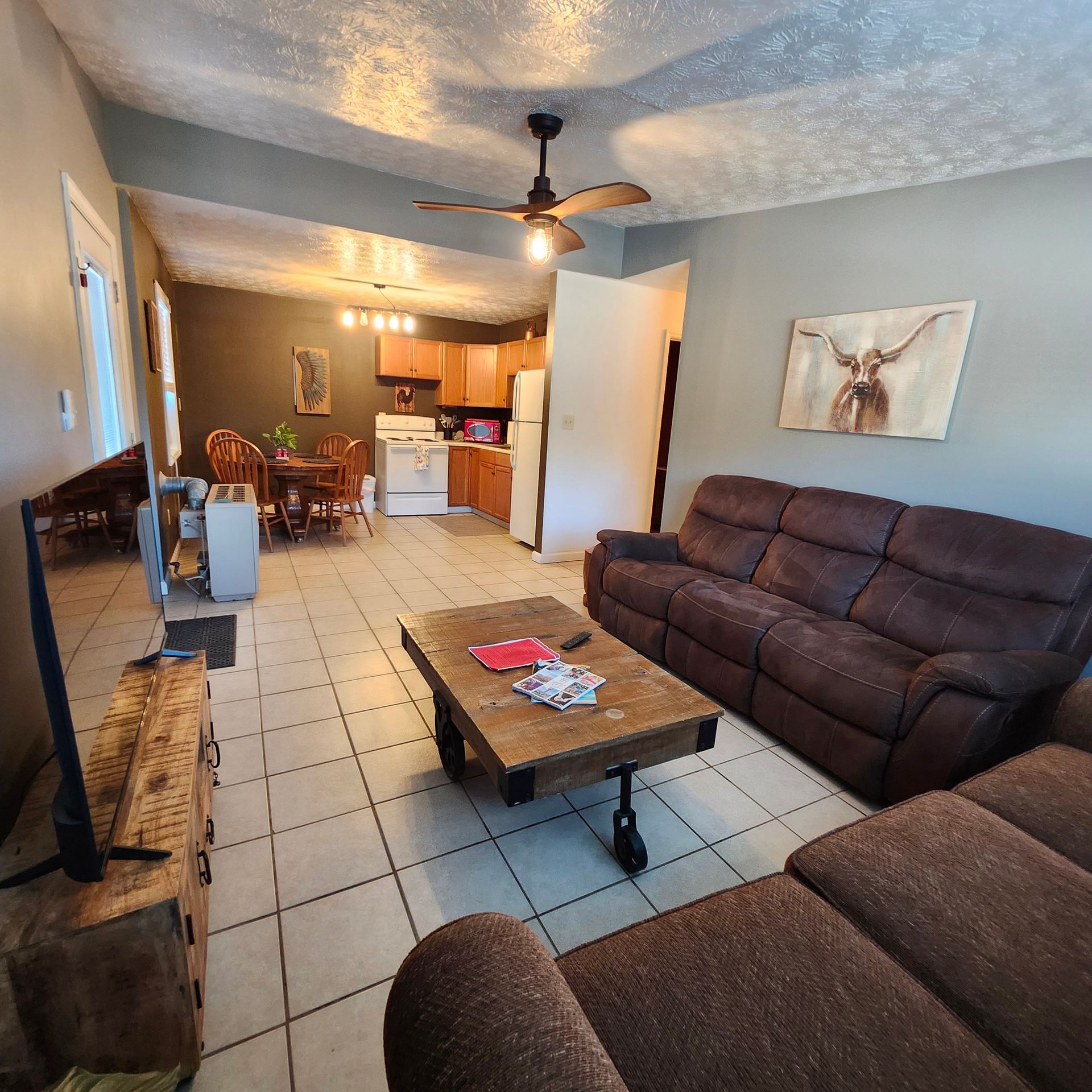 A kitchen with a table and chairs and a refrigerator