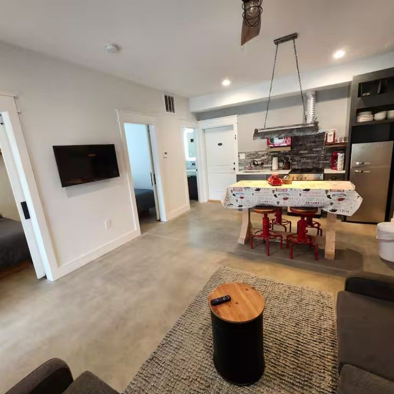 A living room with a table and chairs and a flat screen tv