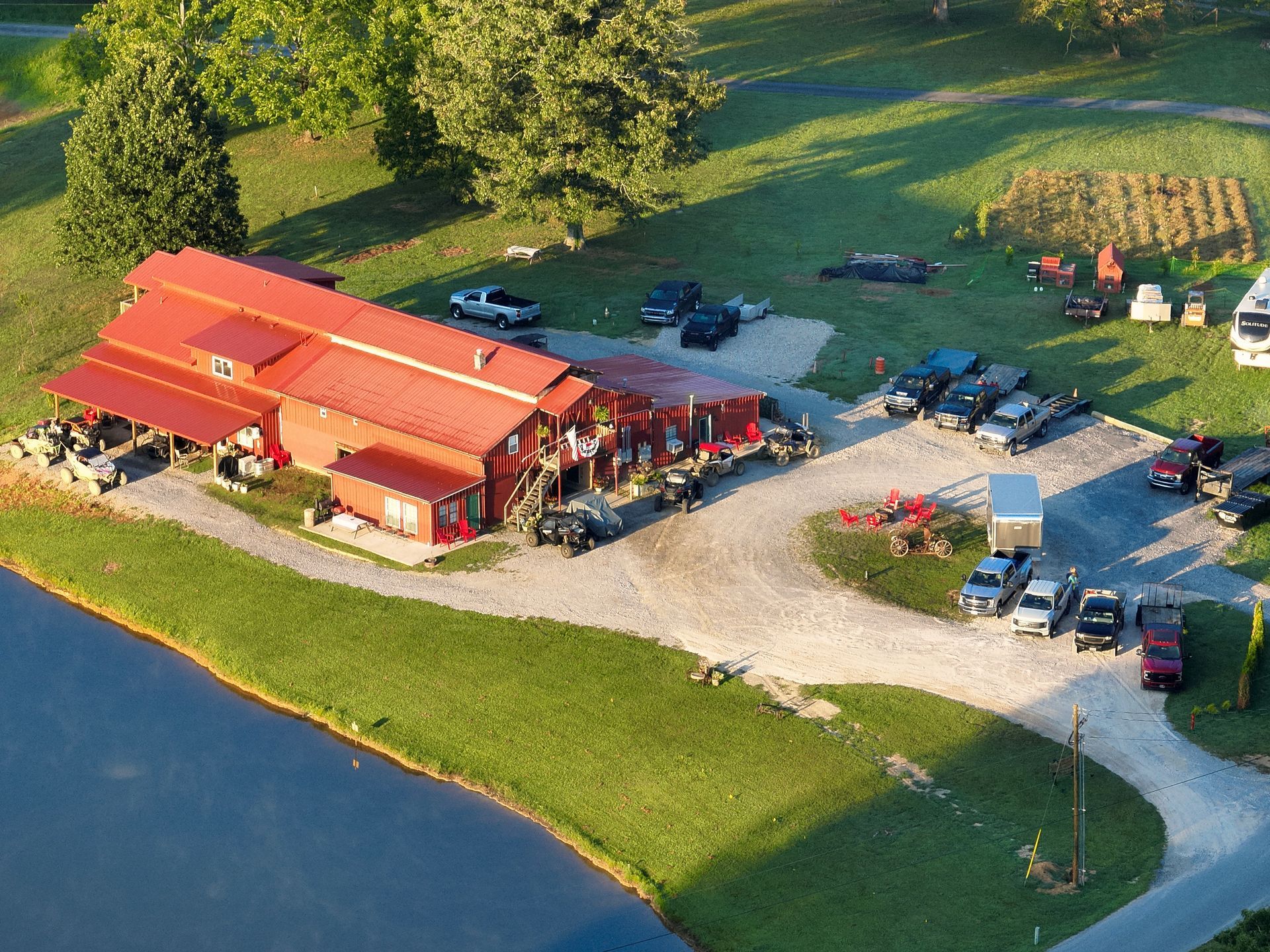 A sunset over a lake with a red house in the background