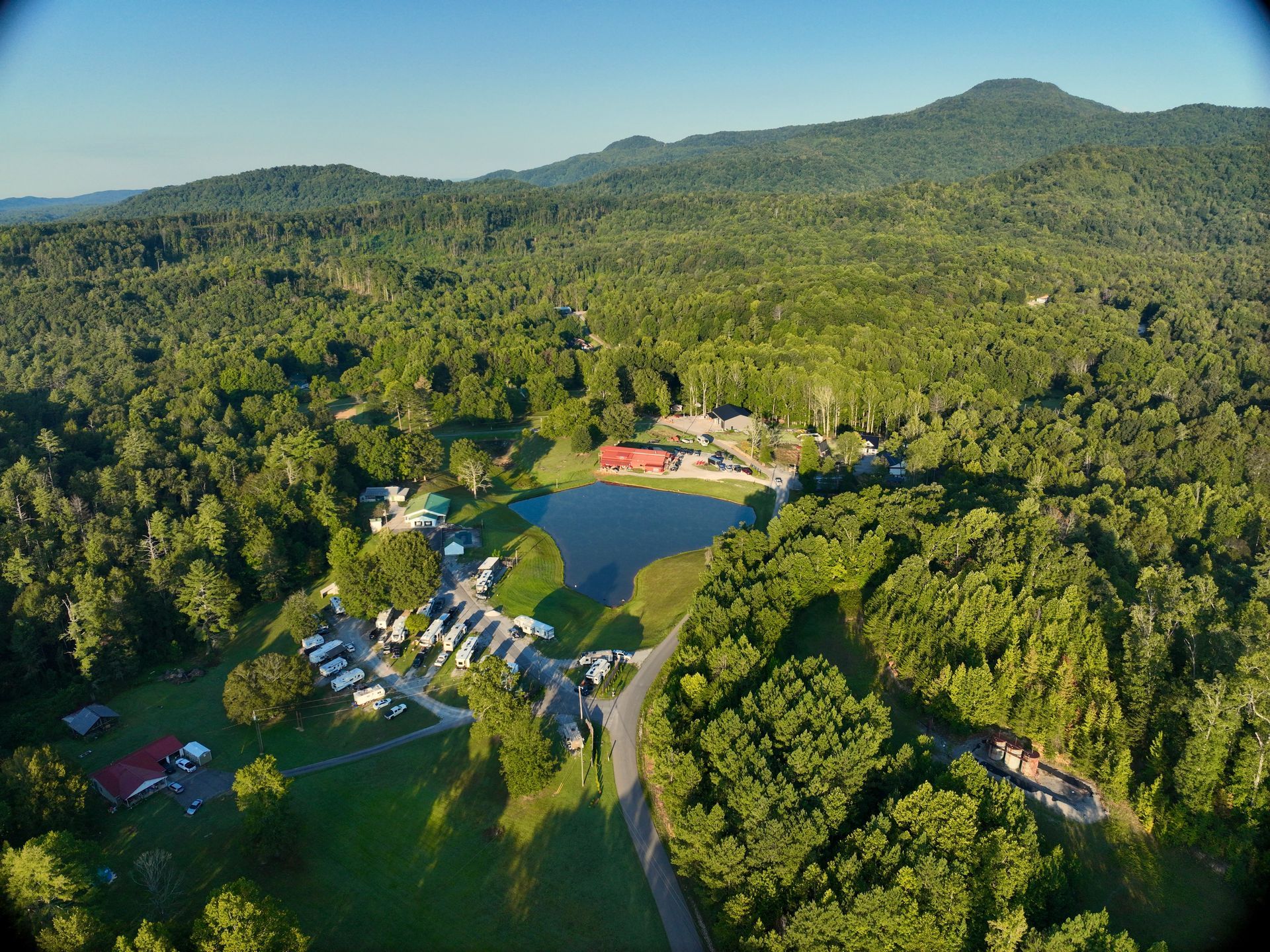 An aerial view of a golf course surrounded by trees and a small pond.