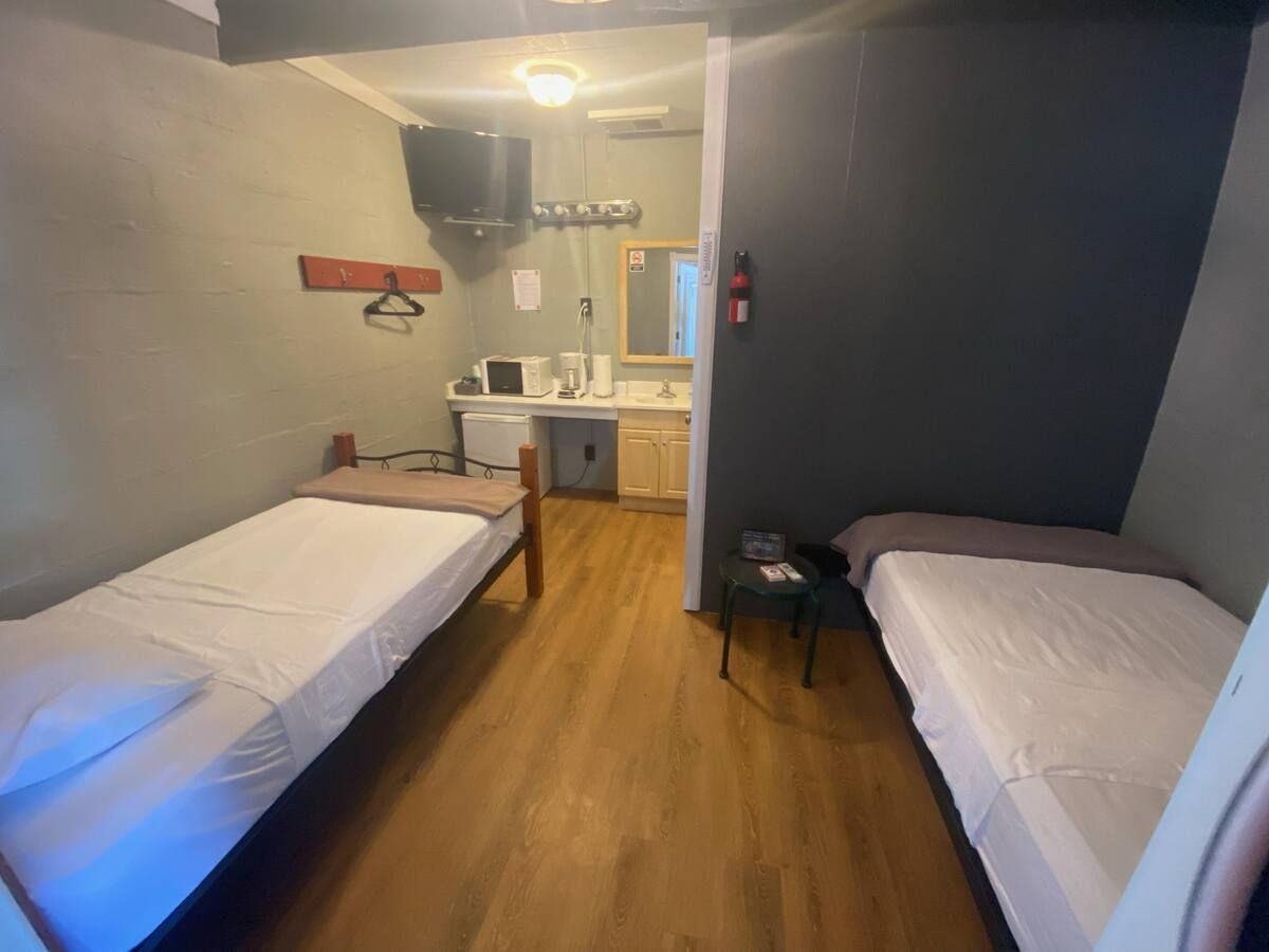 A hotel room with two beds and a sink