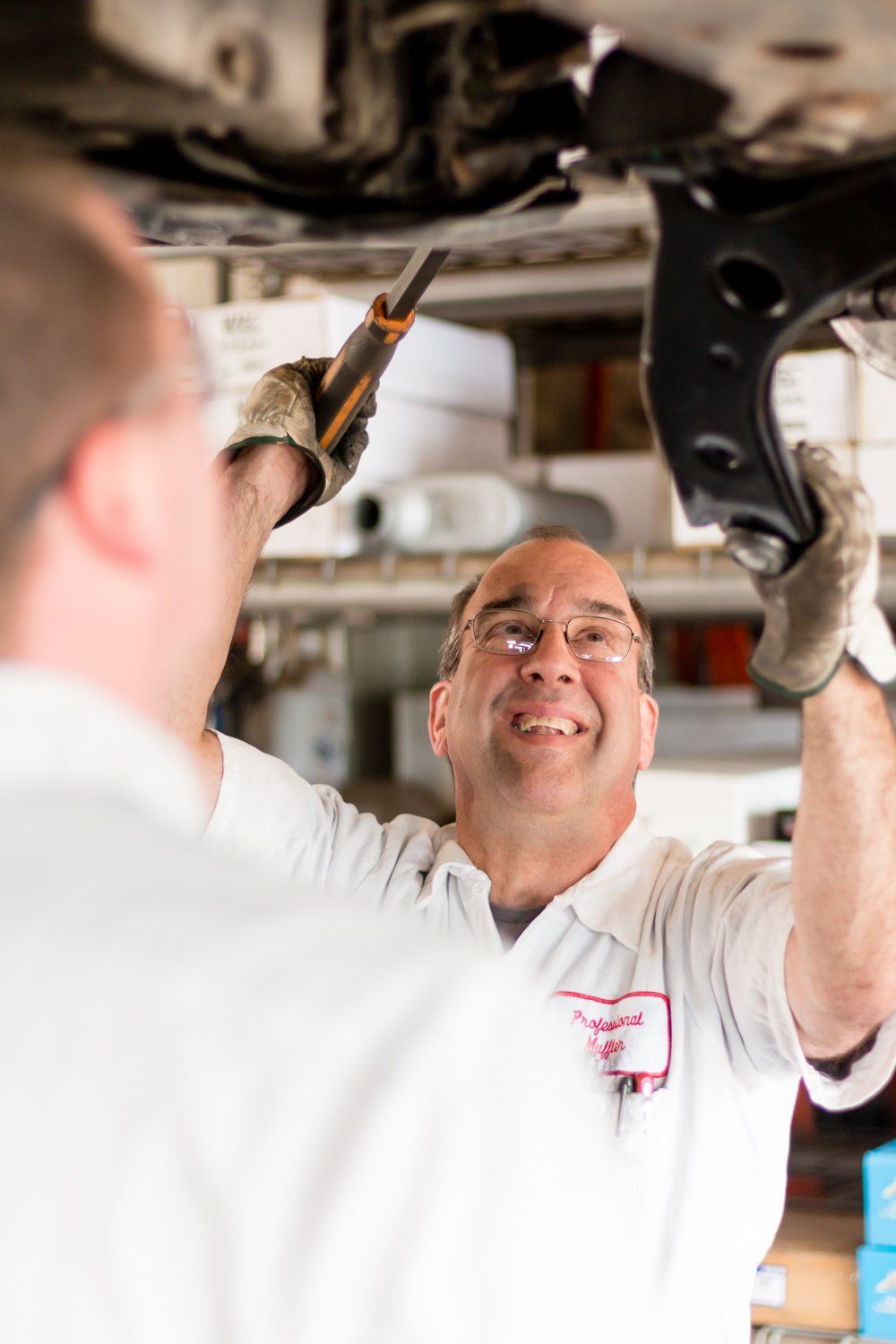 Man Inspecting A Car — Iowa City, IA — Professional Muffler Inc