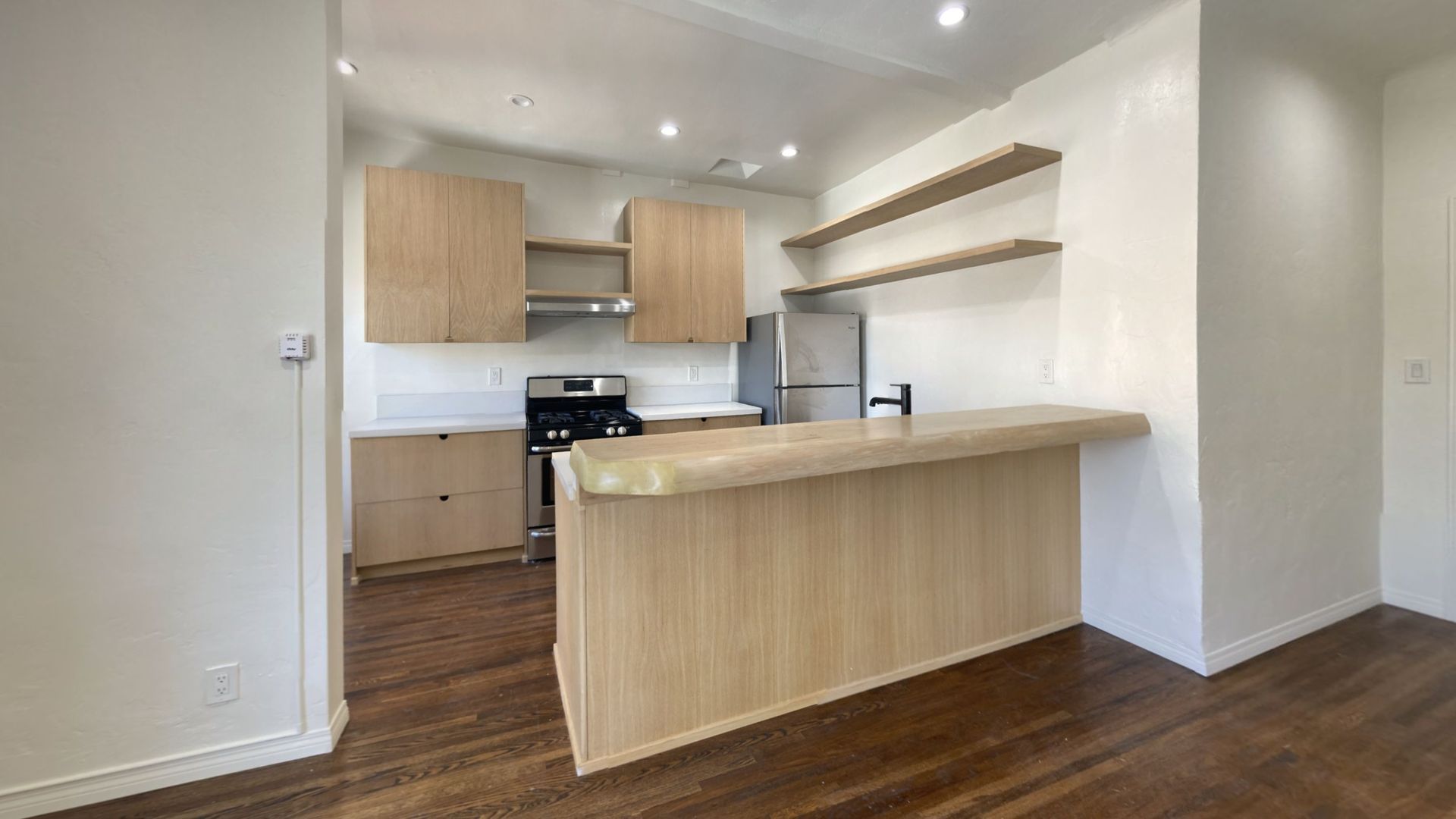 Kitchen with light wood cabinets and a breakfast bar.