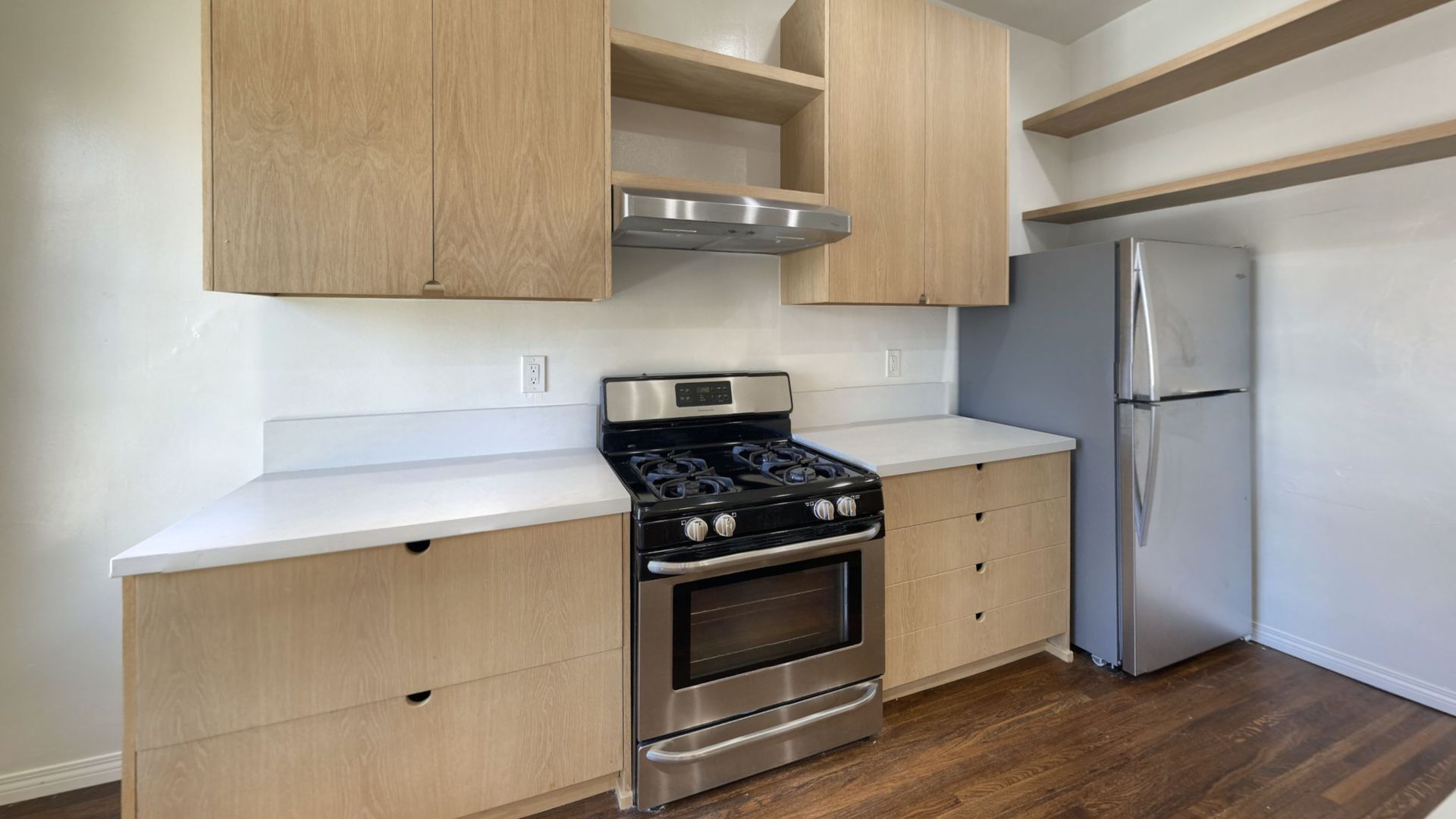 Kitchen with light wood cabinets, stainless steel appliances, and white countertops.