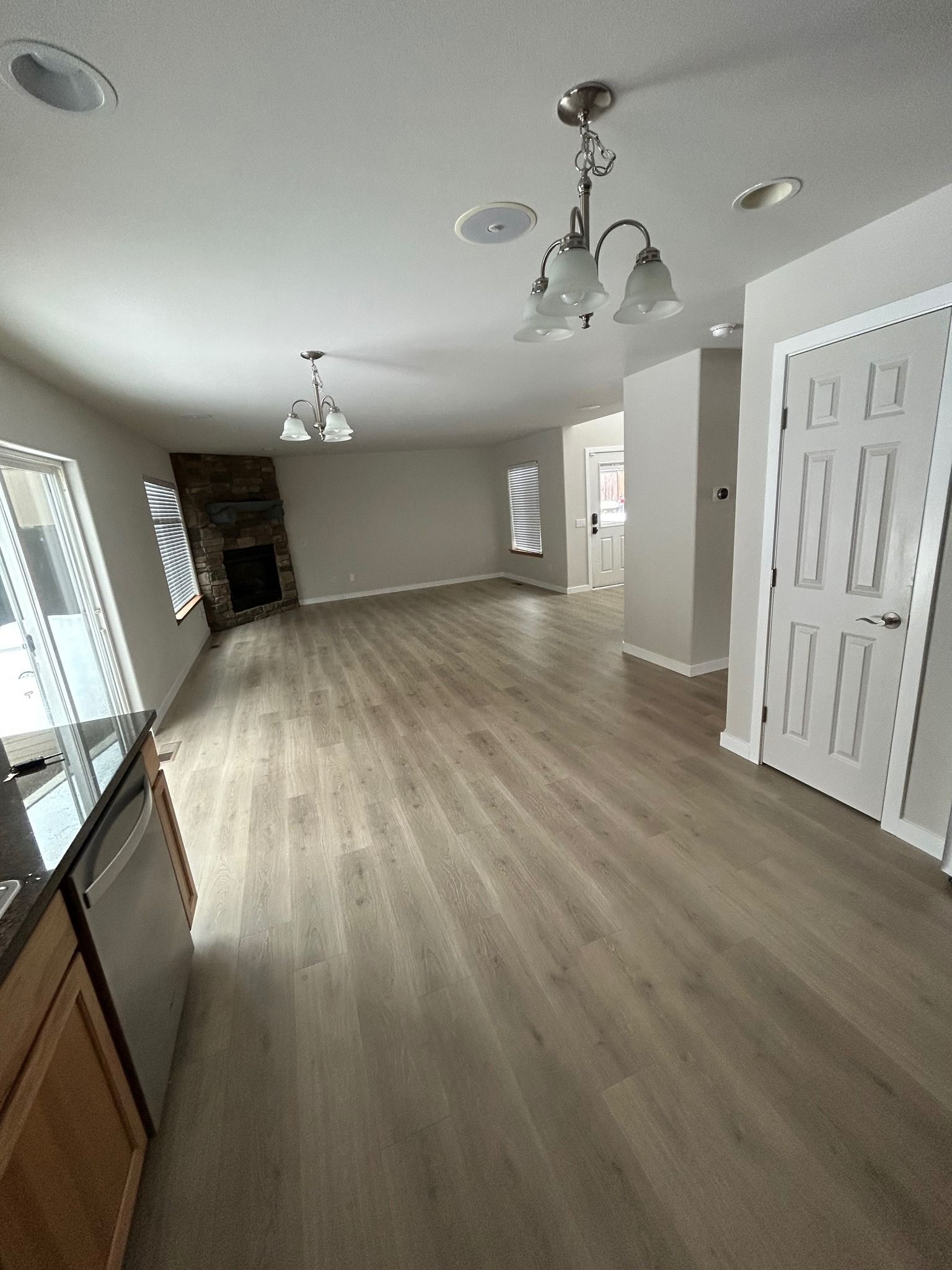 Interior view of a living space with hardwood floors, fireplace, and neutral paint.