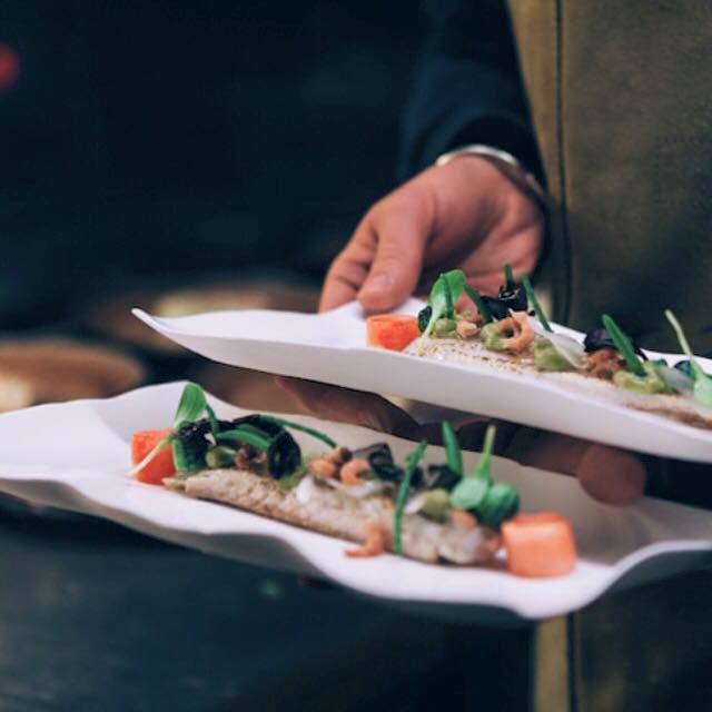 Een persoon houdt twee borden met eten in zijn handen