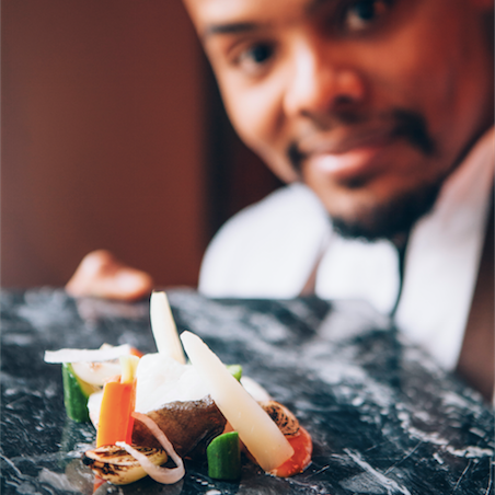 Een man kijkt naar een bord met eten op een tafel