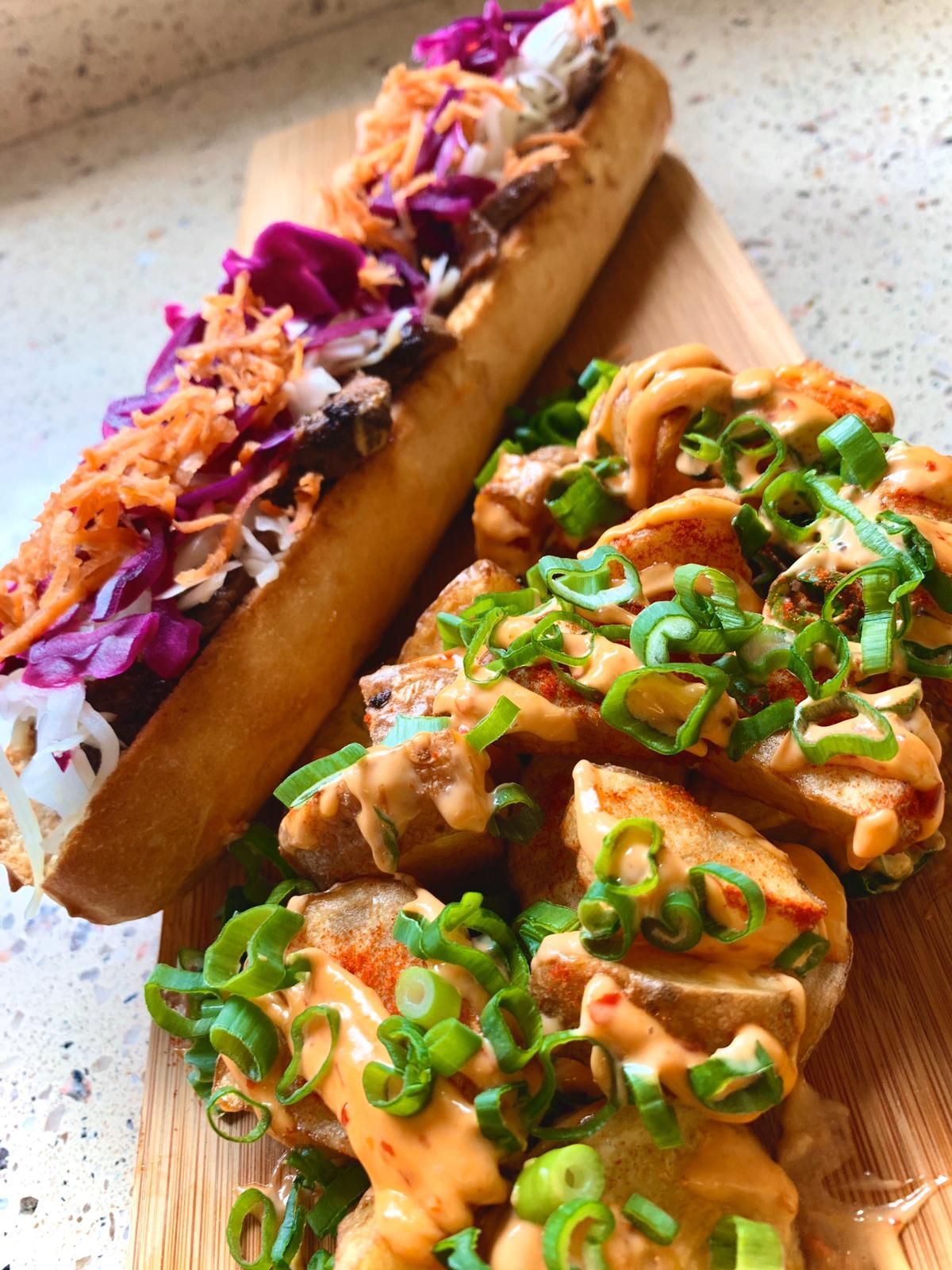 Twee broodjes liggen op een houten snijplank.