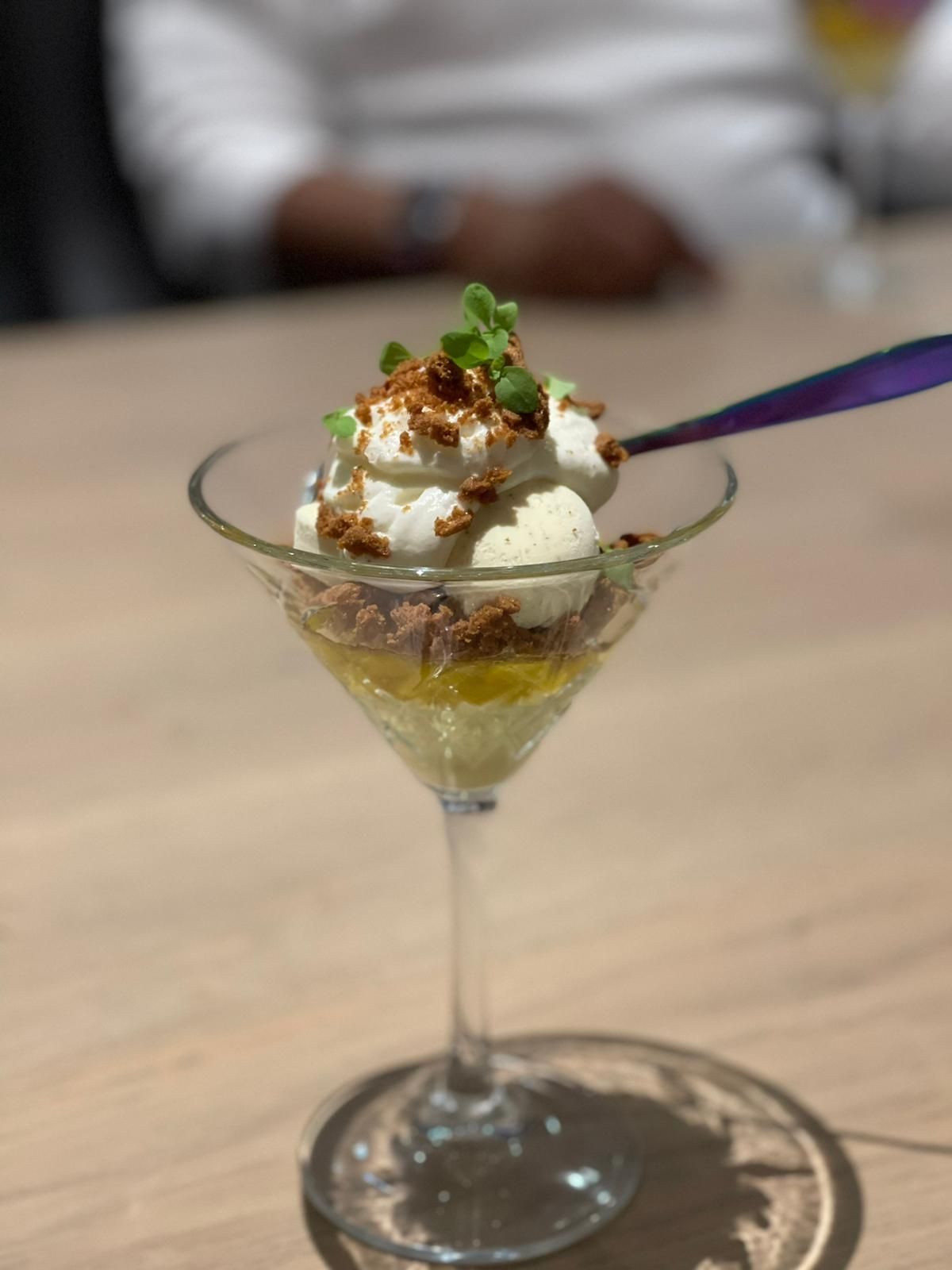 Een dessert in een martiniglas met een lepel erin