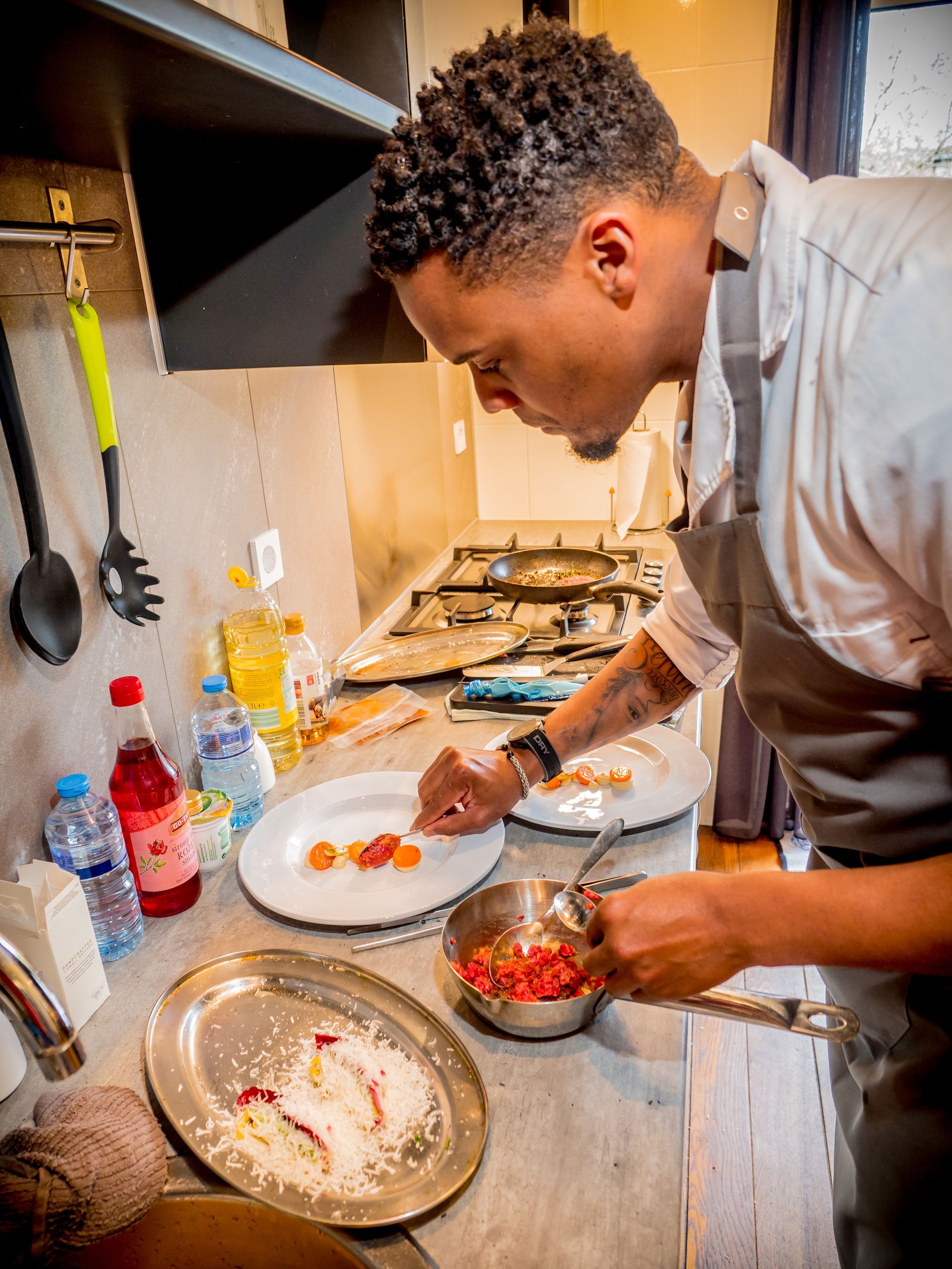 Een man met een schort aan bereidt eten in de keuken.