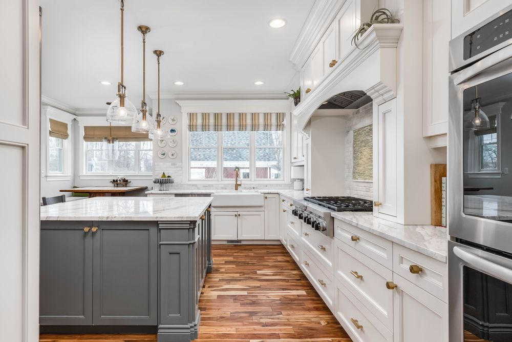 A kitchen with white cabinets , stainless steel appliances , and hardwood floors.