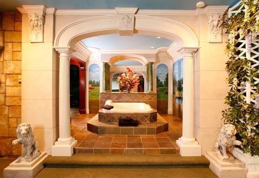 A bathroom with columns and a jacuzzi tub
