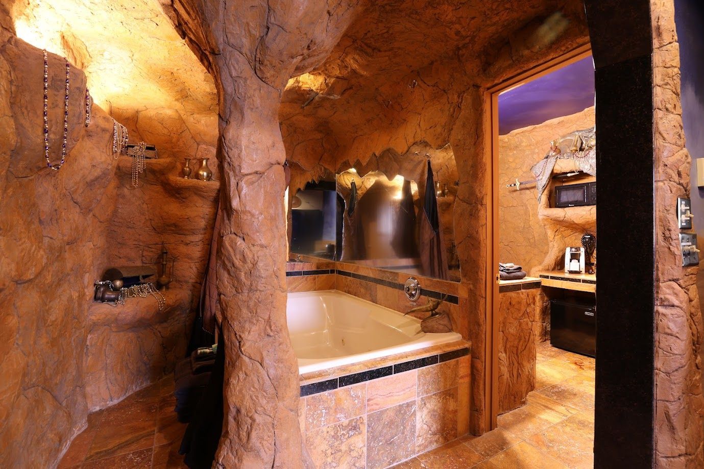 A bathroom with a bathtub in the middle of a cave.